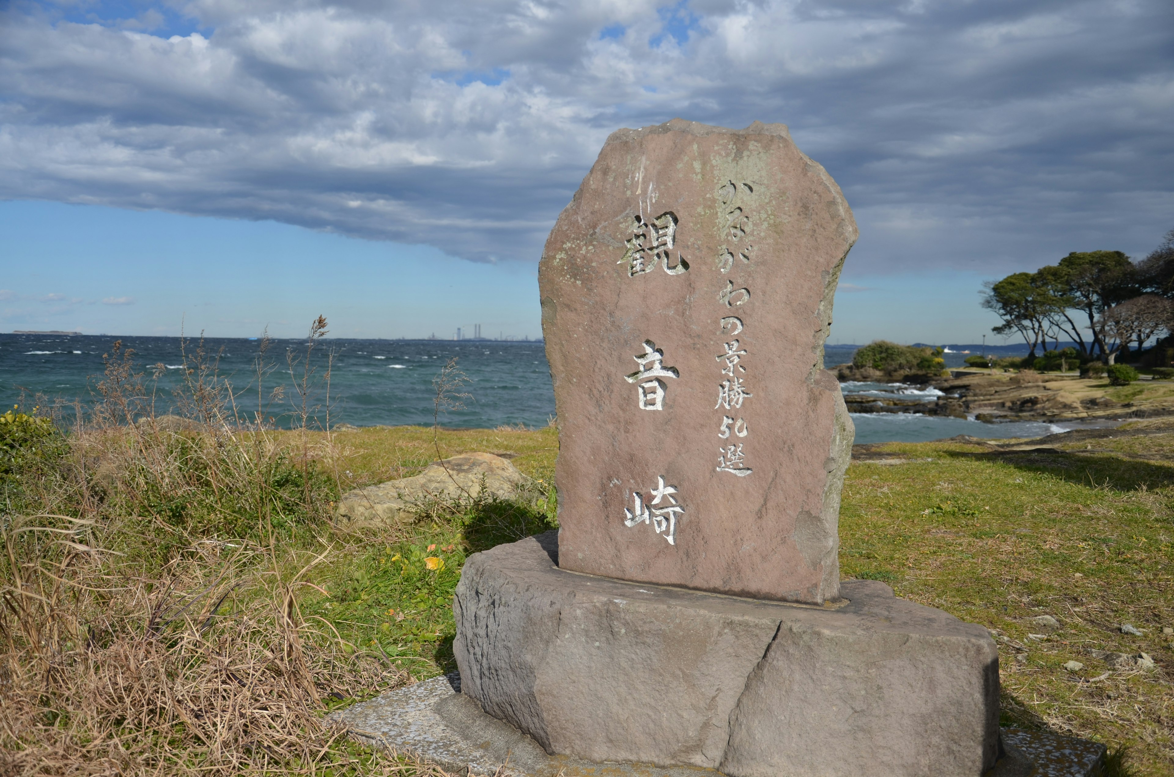 Large stone monument near the sea with inscribed characters