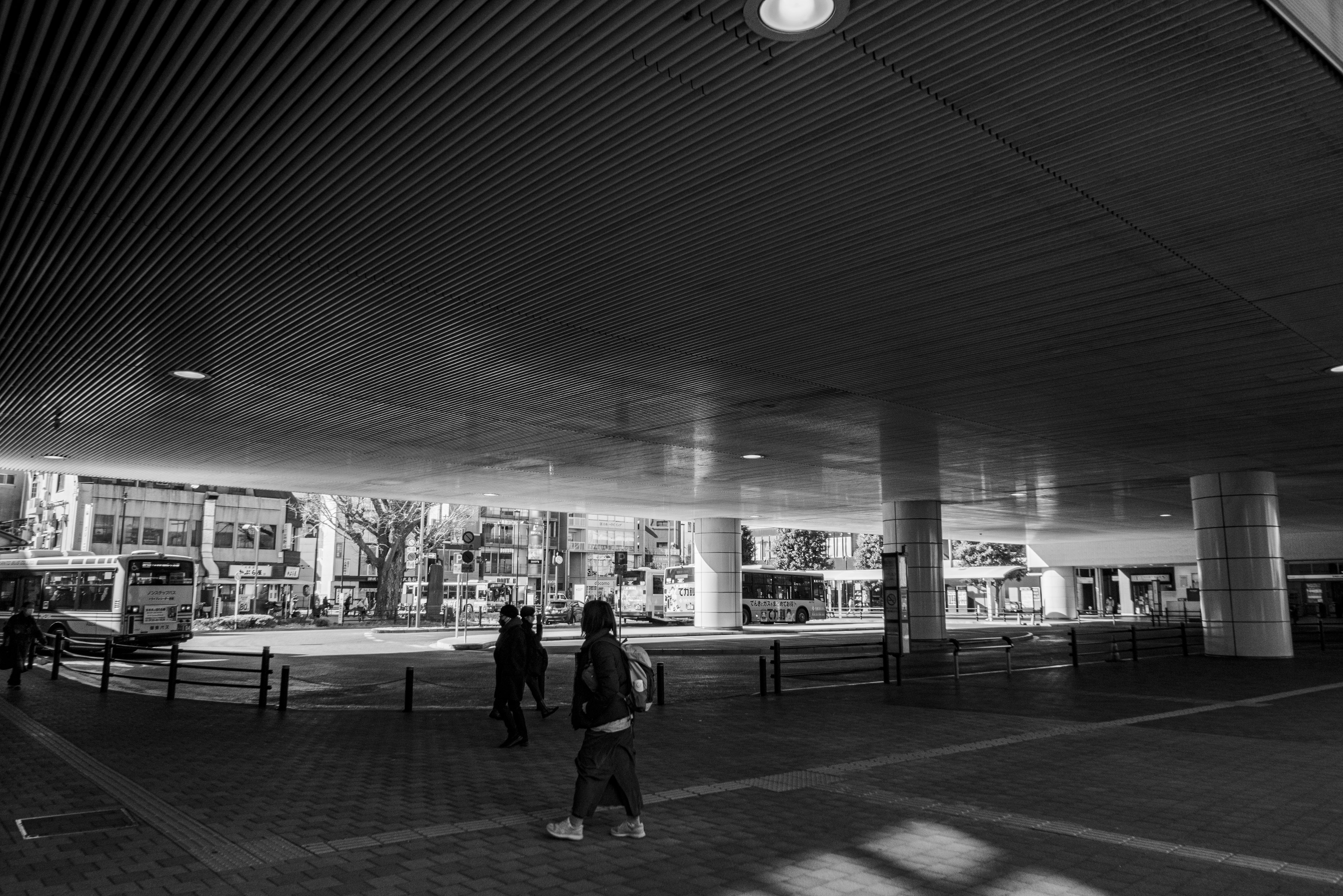 Personas caminando en una plaza subterránea con arquitectura moderna