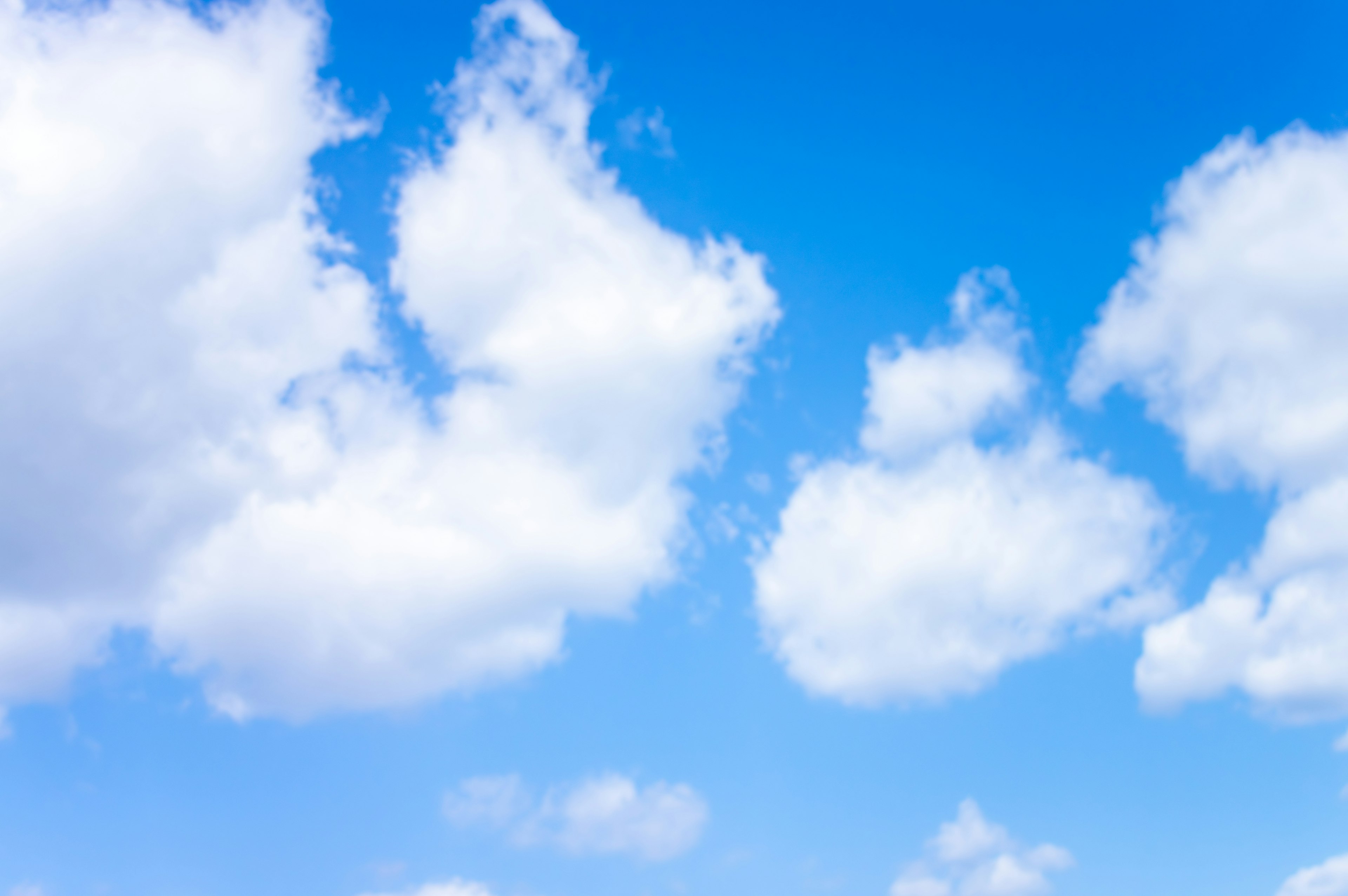 Eine Landschaft mit weißen Wolken, die in einem blauen Himmel schweben