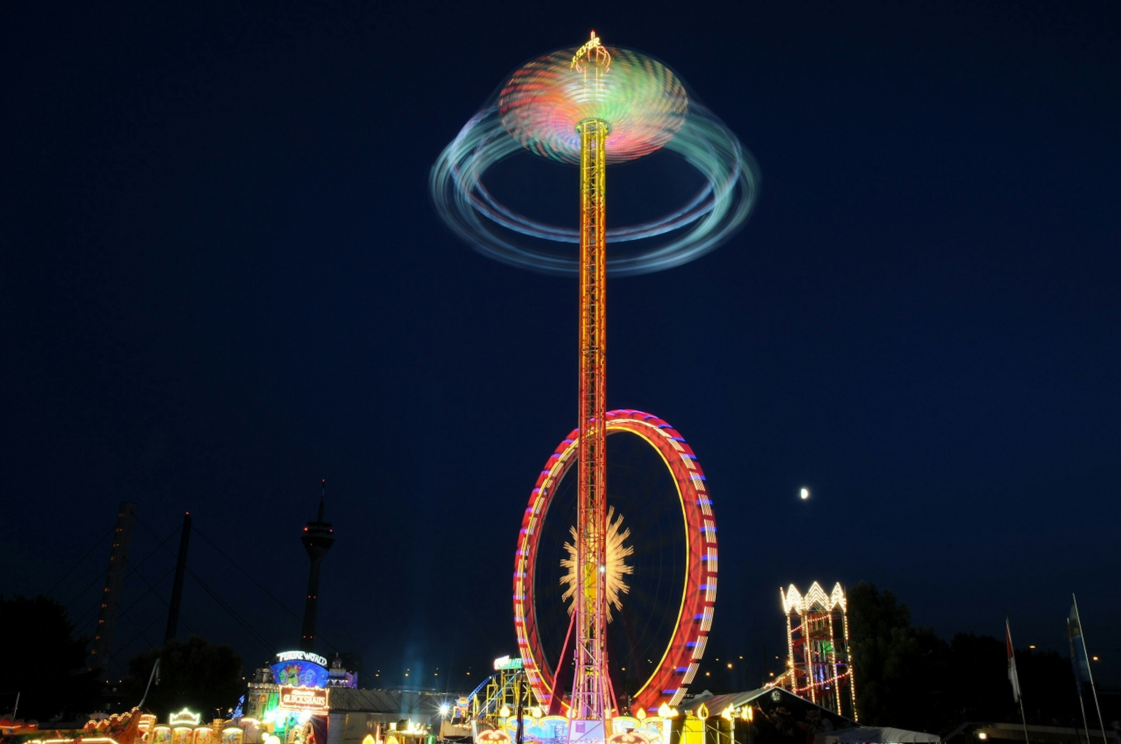 Photo of a thrilling attraction illuminated at night in an amusement park