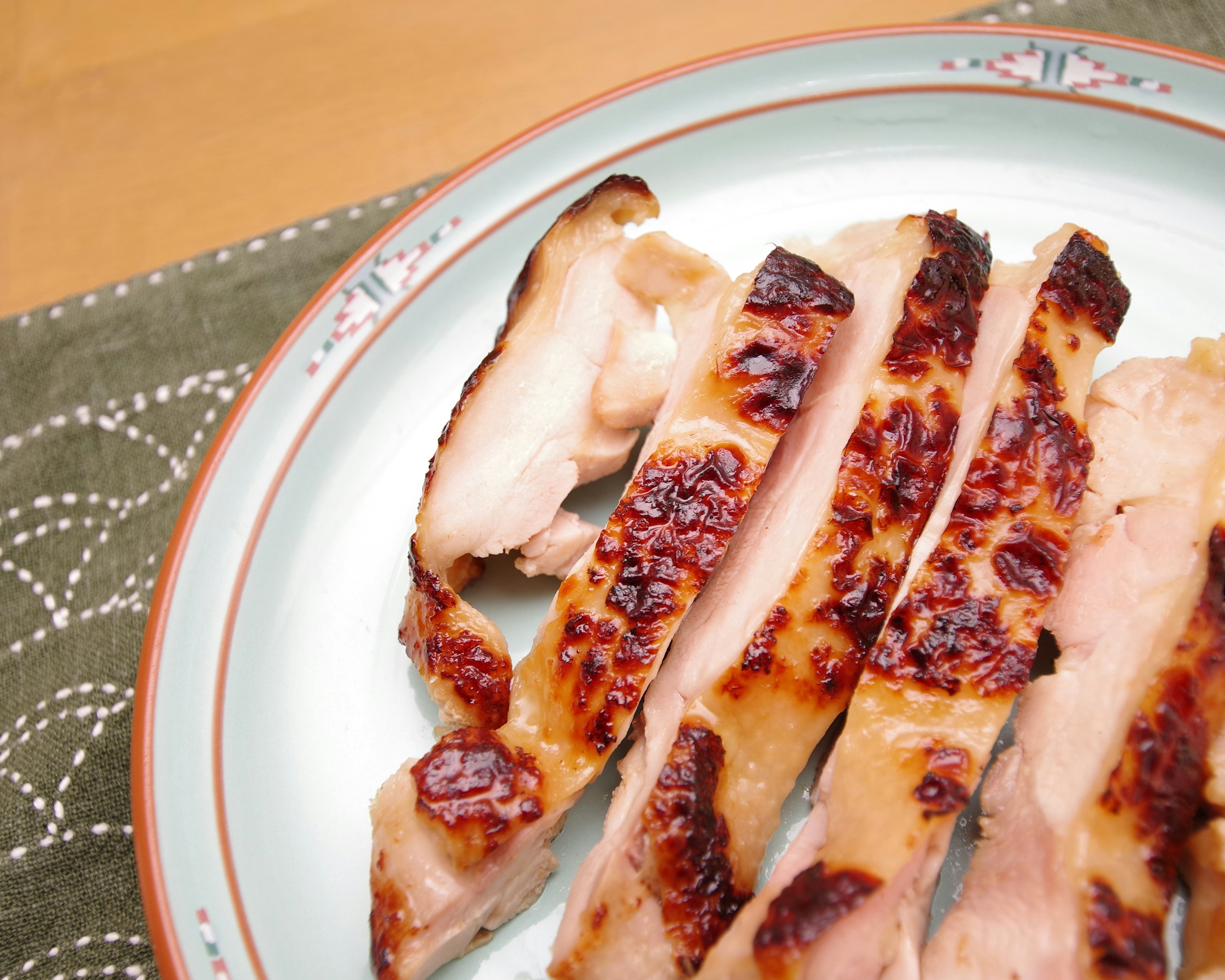 Pollo a la parrilla en rodajas presentado en un plato decorativo