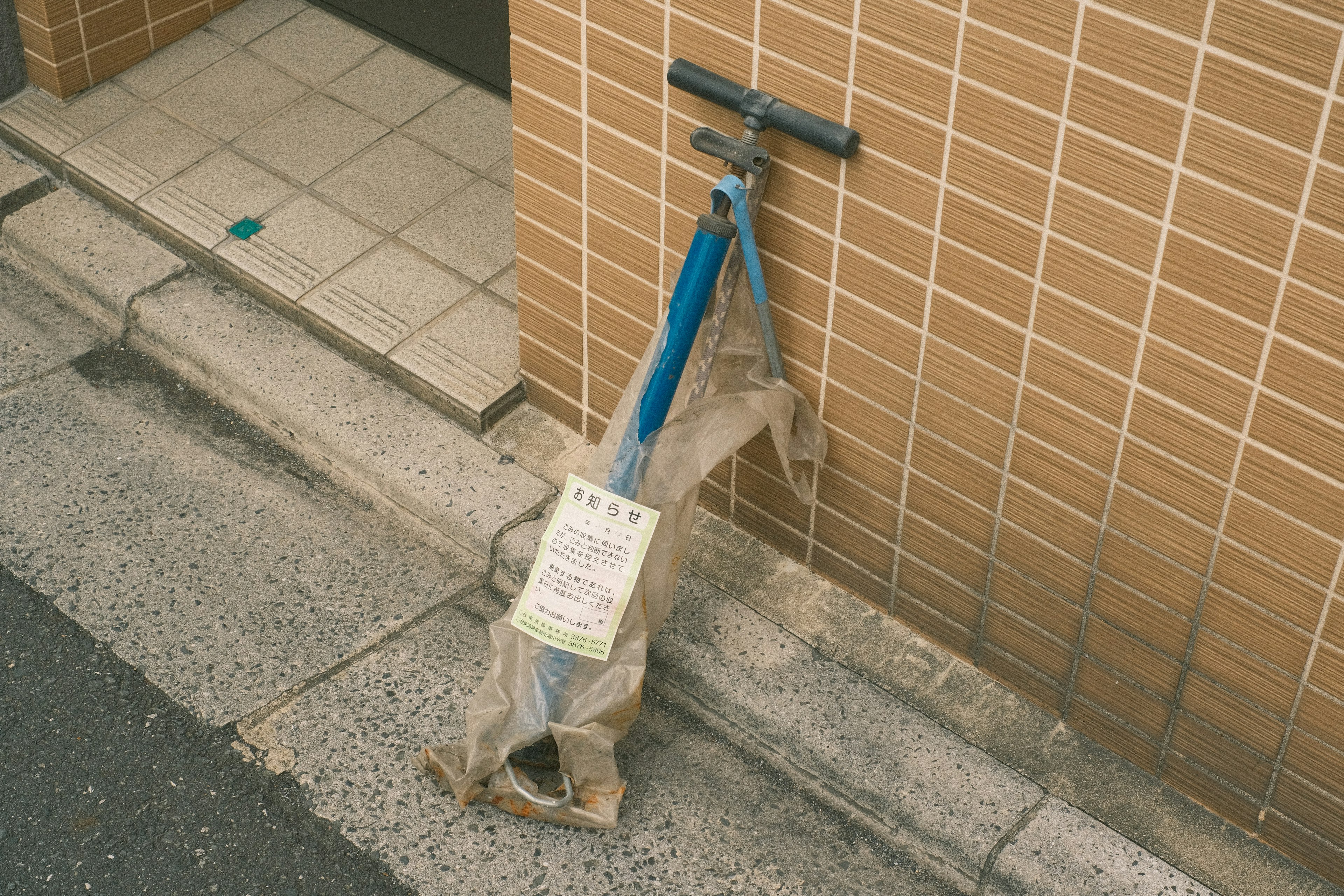 蓝色铲子靠在棕色瓷砖墙上