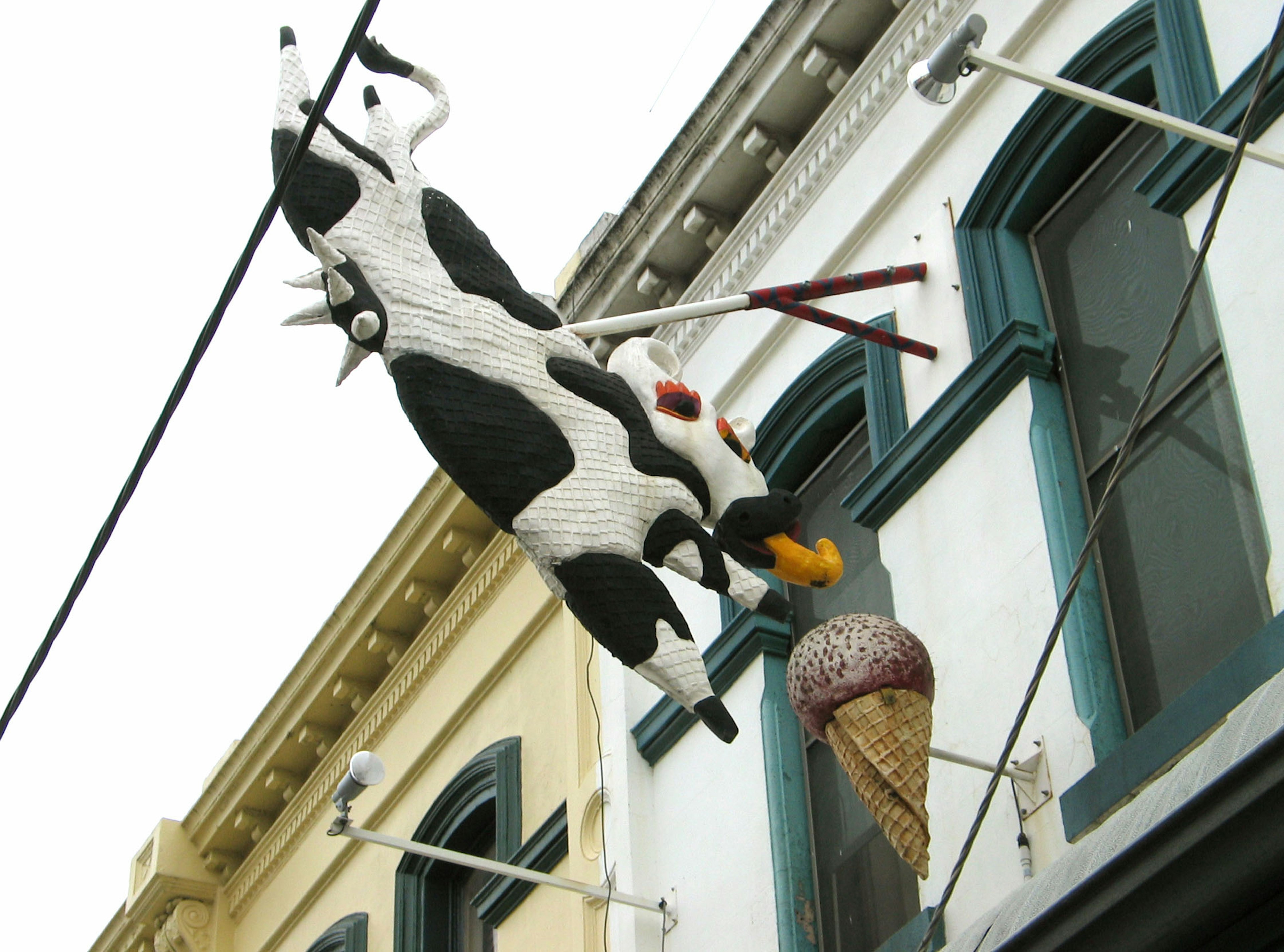 Una escultura de vaca divertida sosteniendo un cono de helado