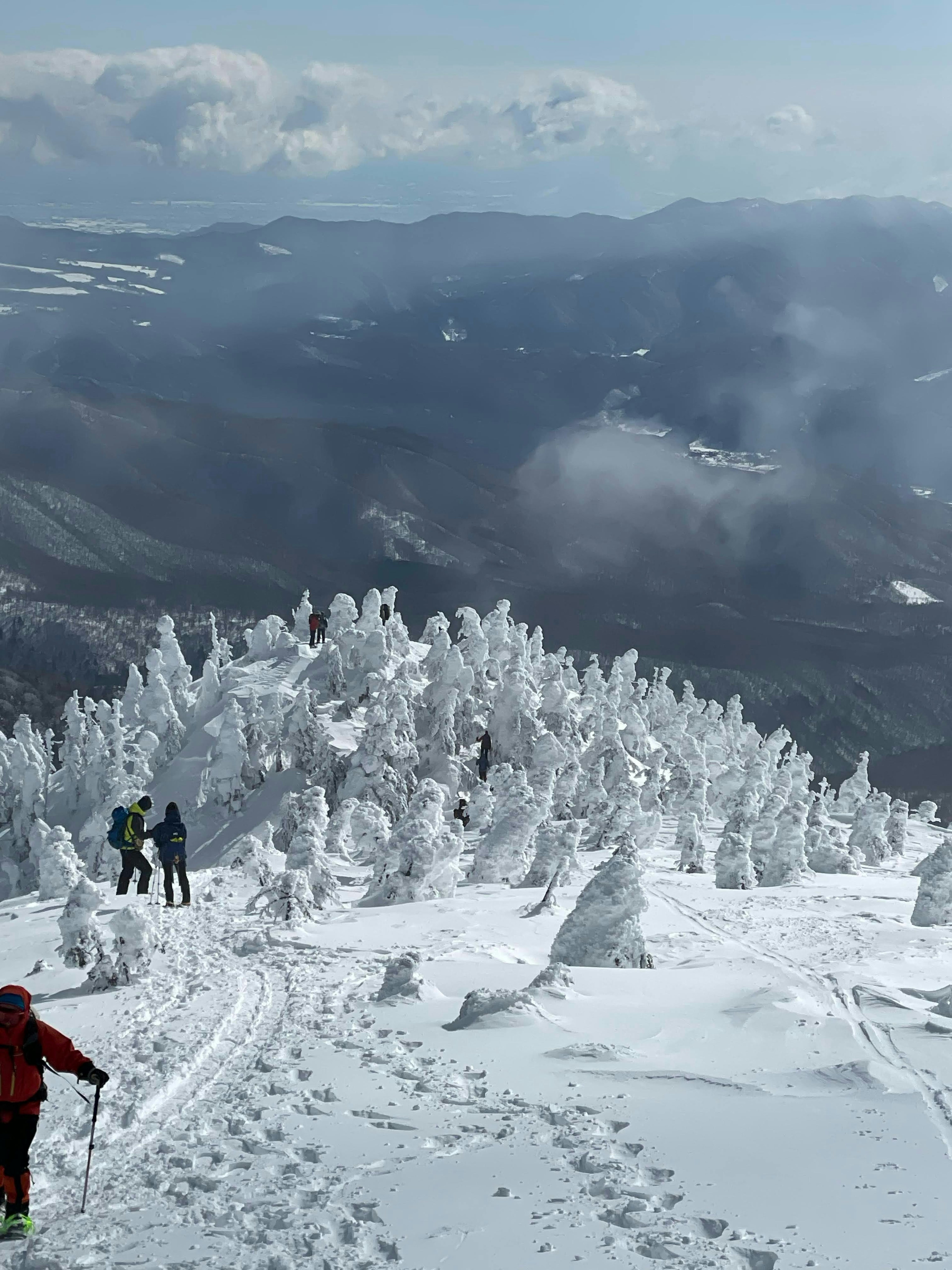 Schneebedeckter Berggipfel mit Wanderern und einzigartigen Eisskulpturen