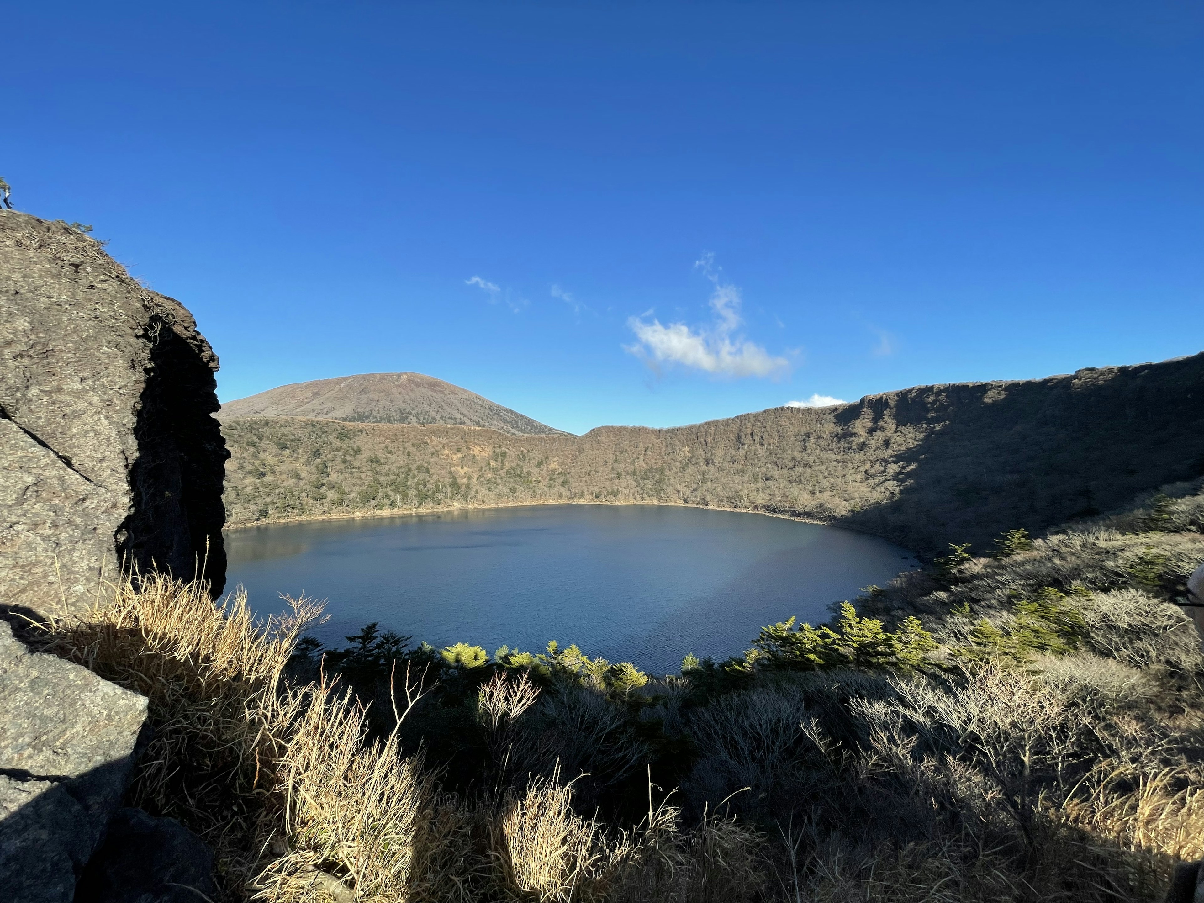 Vista escénica de un lago de cráter volcánico rodeado de montañas