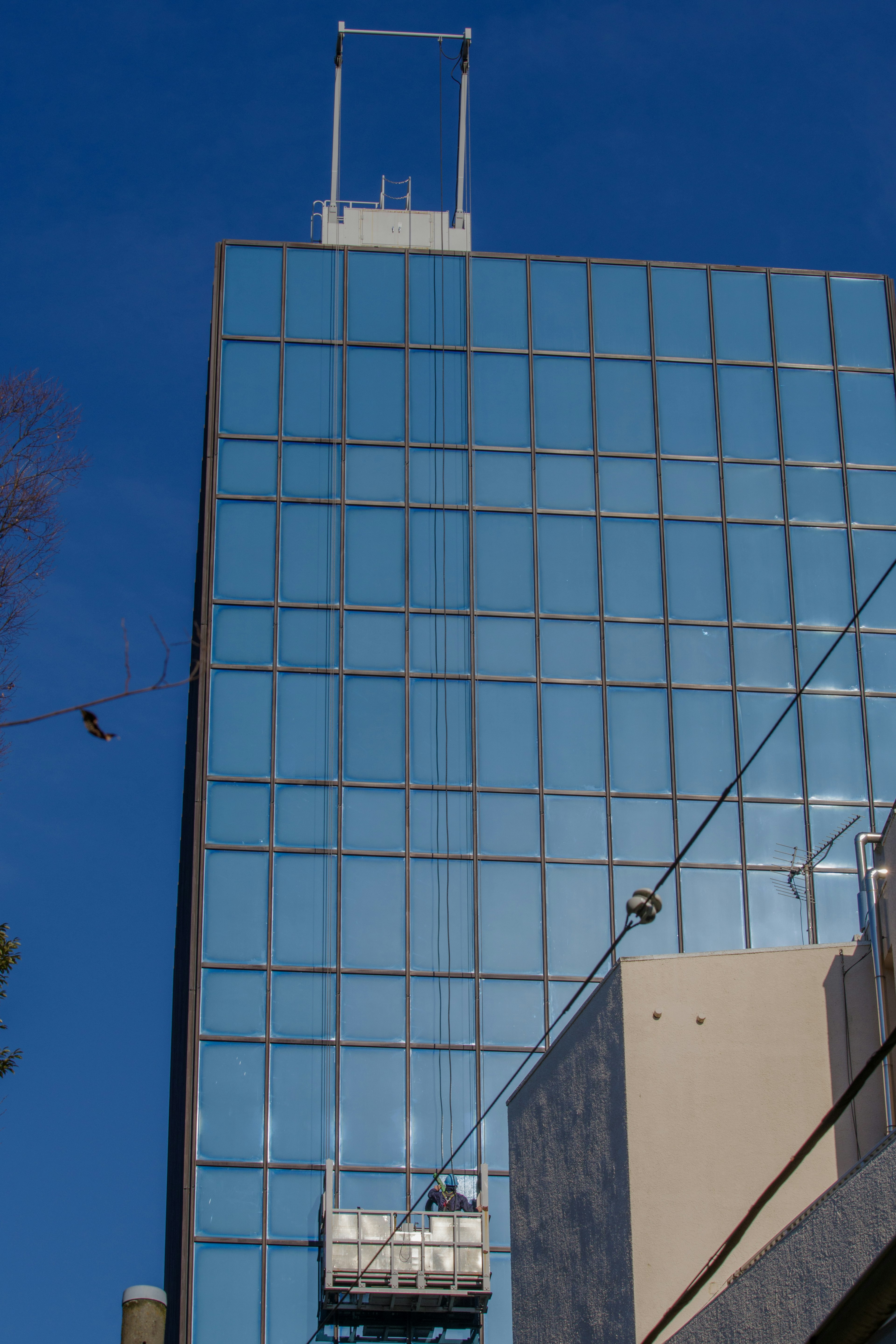 Edificio alto con facciata in vetro riflettente e cielo blu