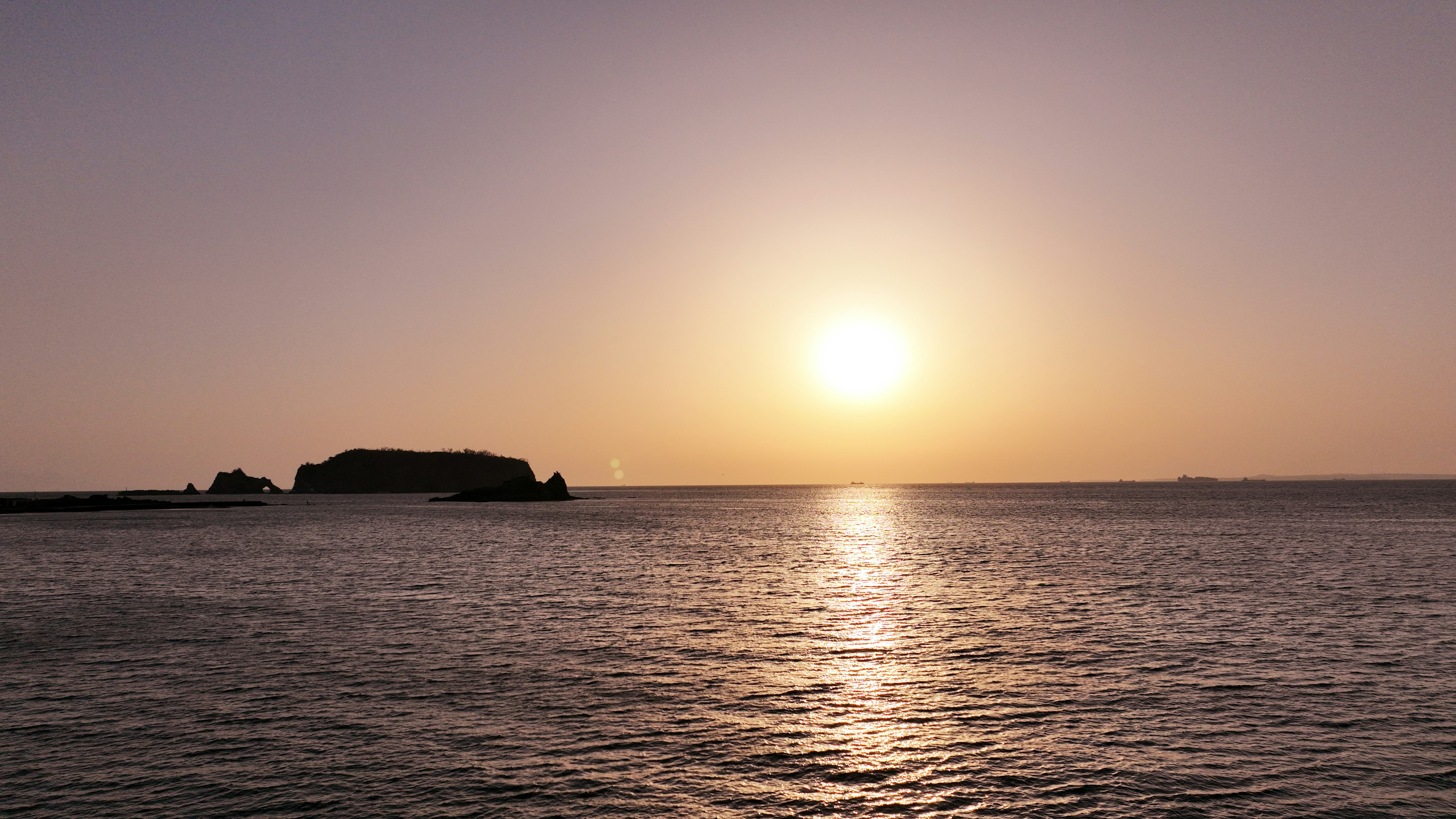 Un tranquillo tramonto sull'oceano con la silhouette di un'isola