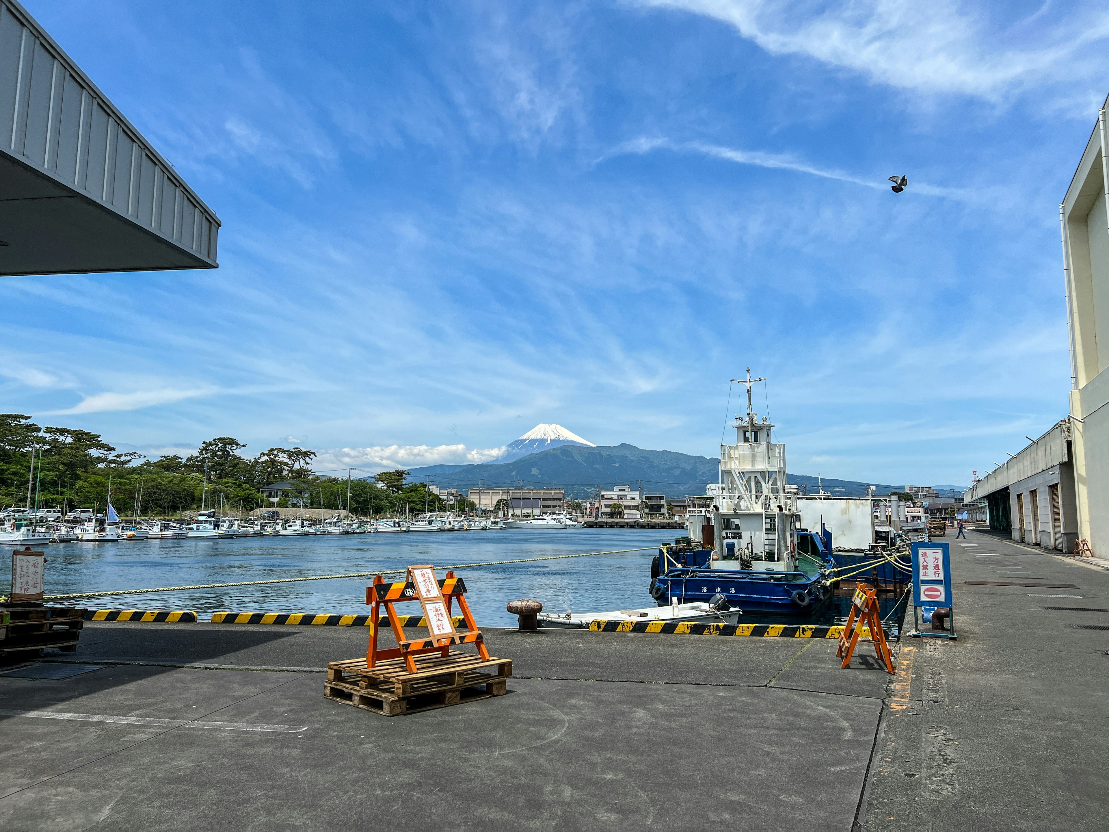 Remolcador atracado en un puerto bajo un cielo azul con nubes