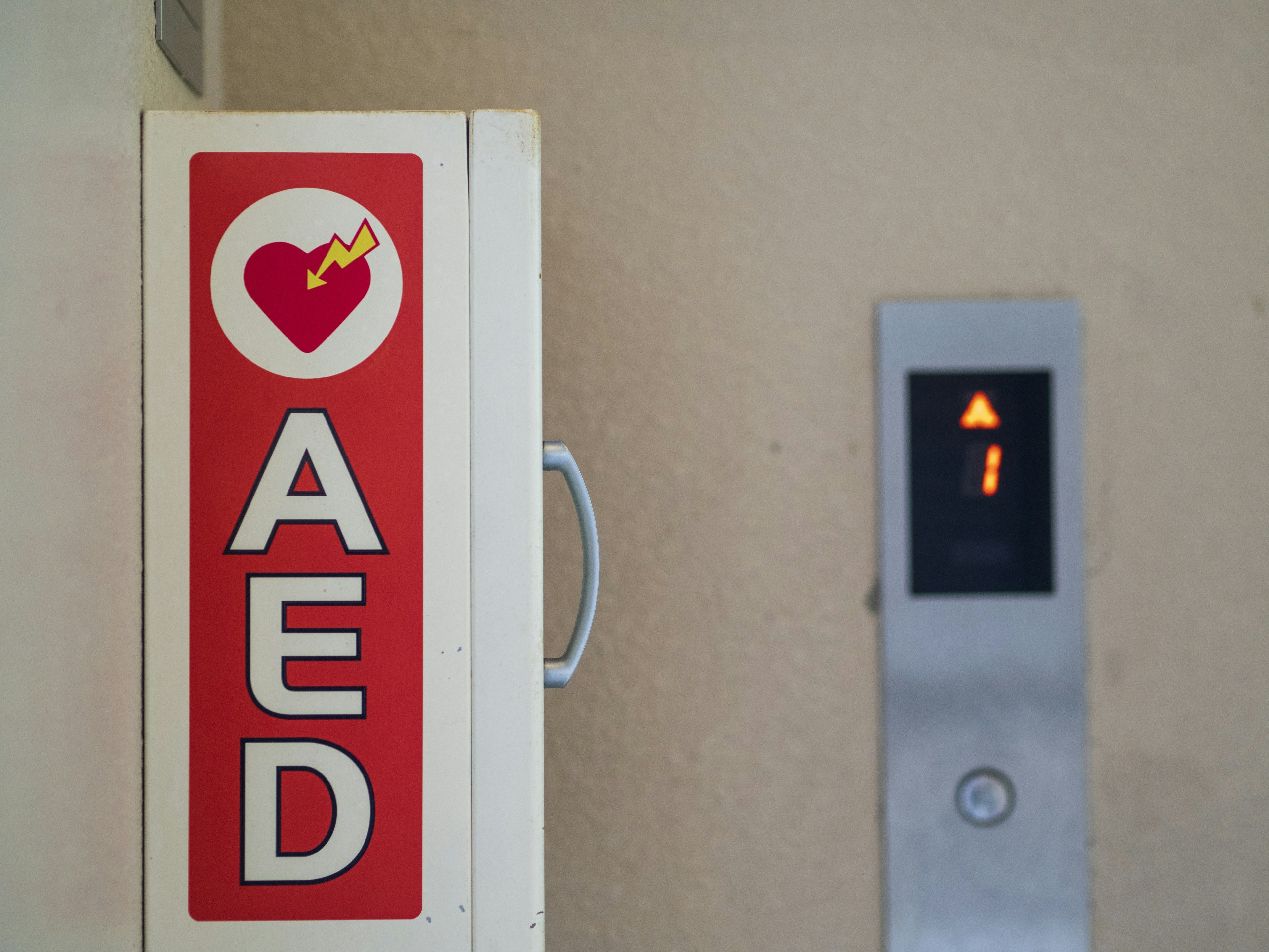 Image montrant un cabinet AED et un bouton d'ascenseur