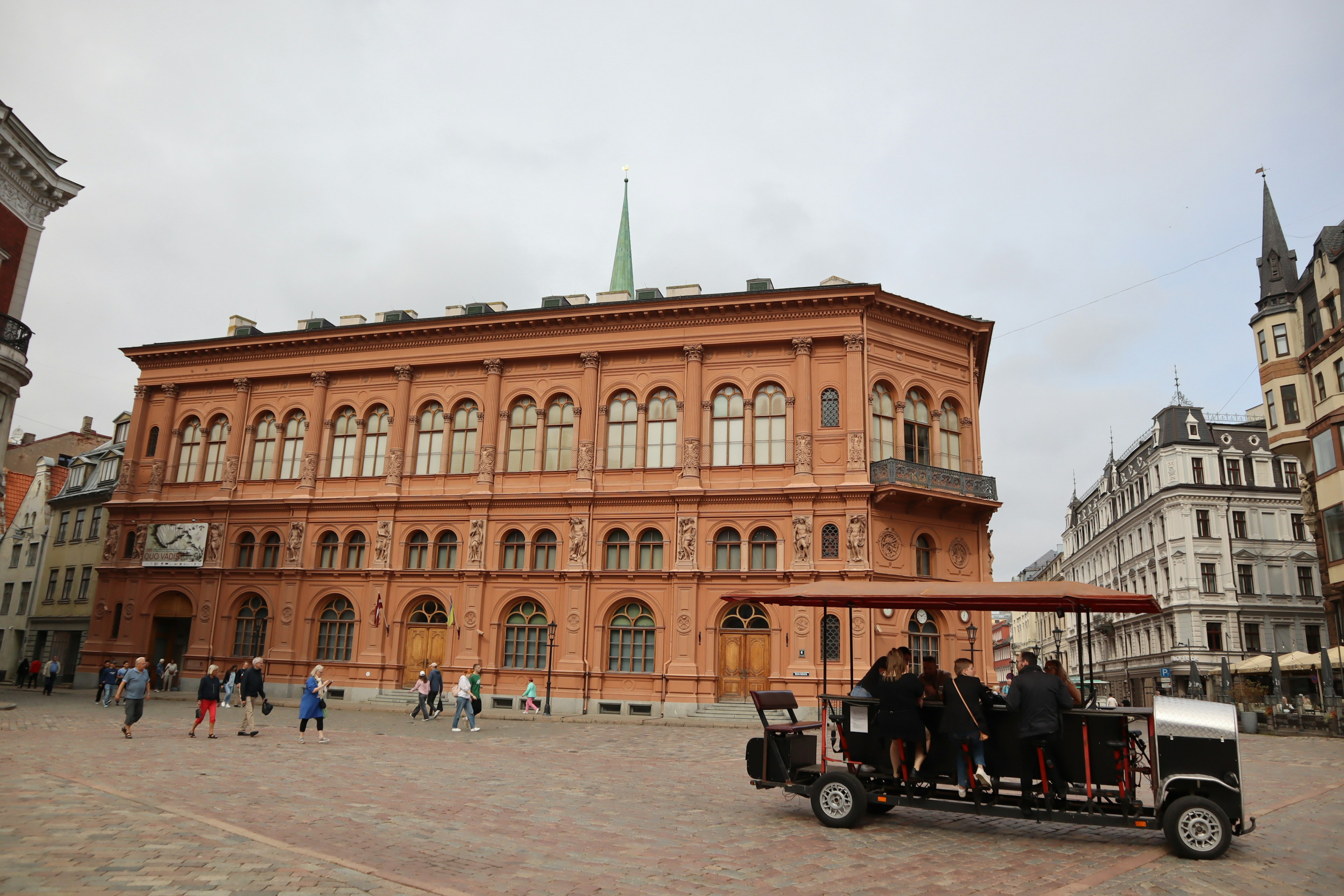 Rotes Backsteingebäude mit Menschen auf einem Platz