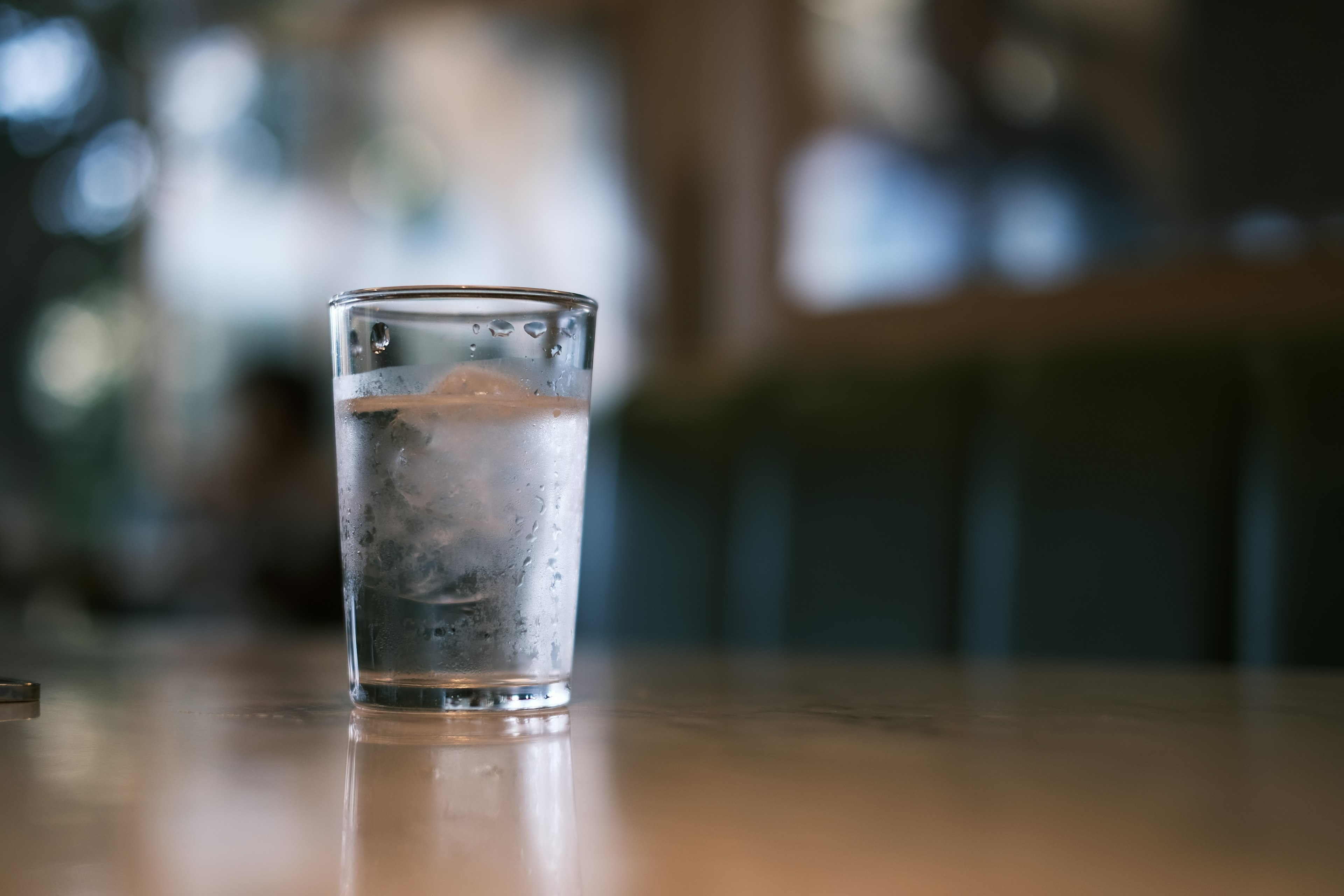 A clear glass of iced water placed on a wooden table