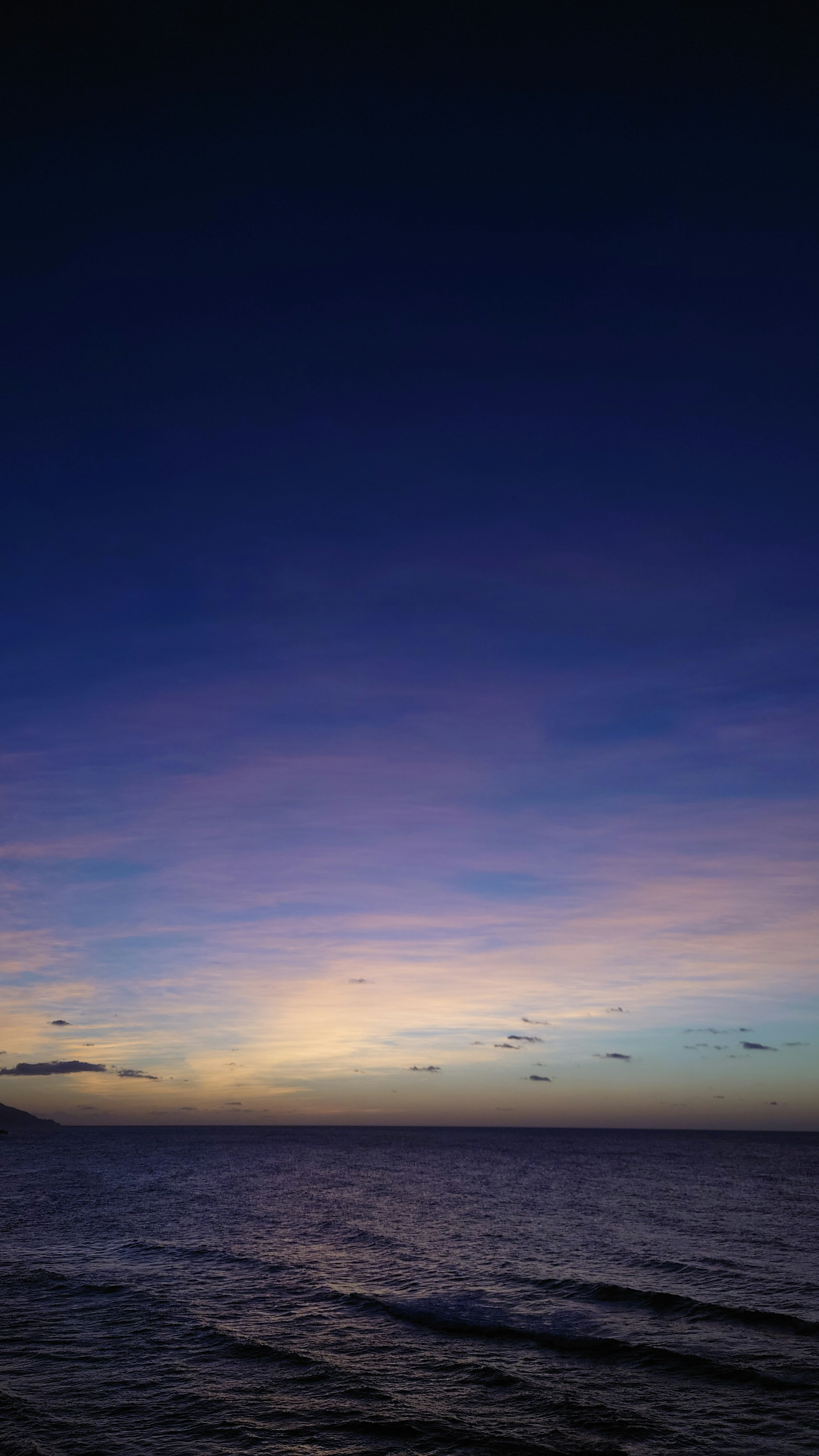 Pemandangan laut saat senja dengan langit biru dan ungu