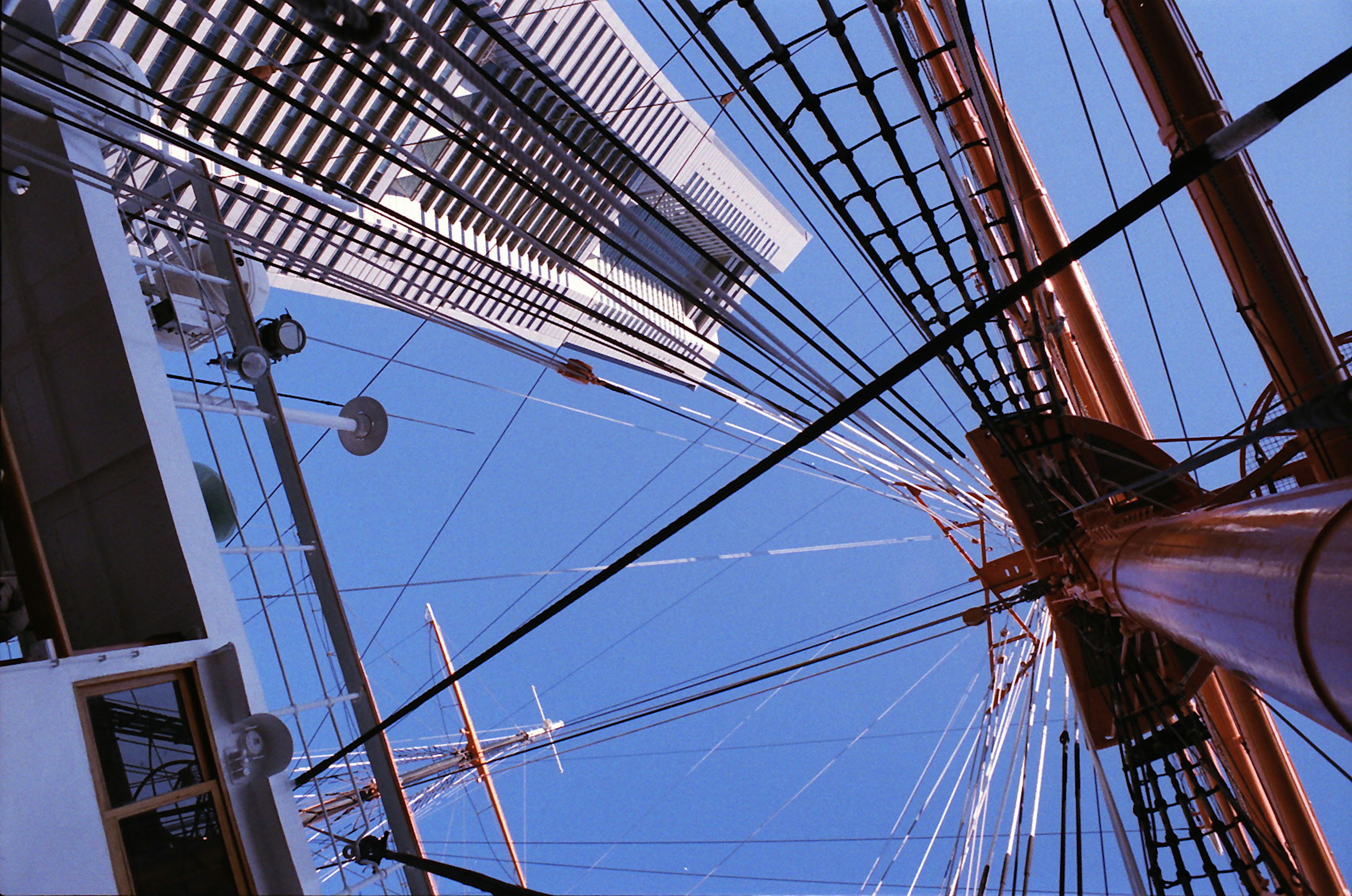 Vista en perspectiva del mástil de un barco y la estructura de un rascacielos