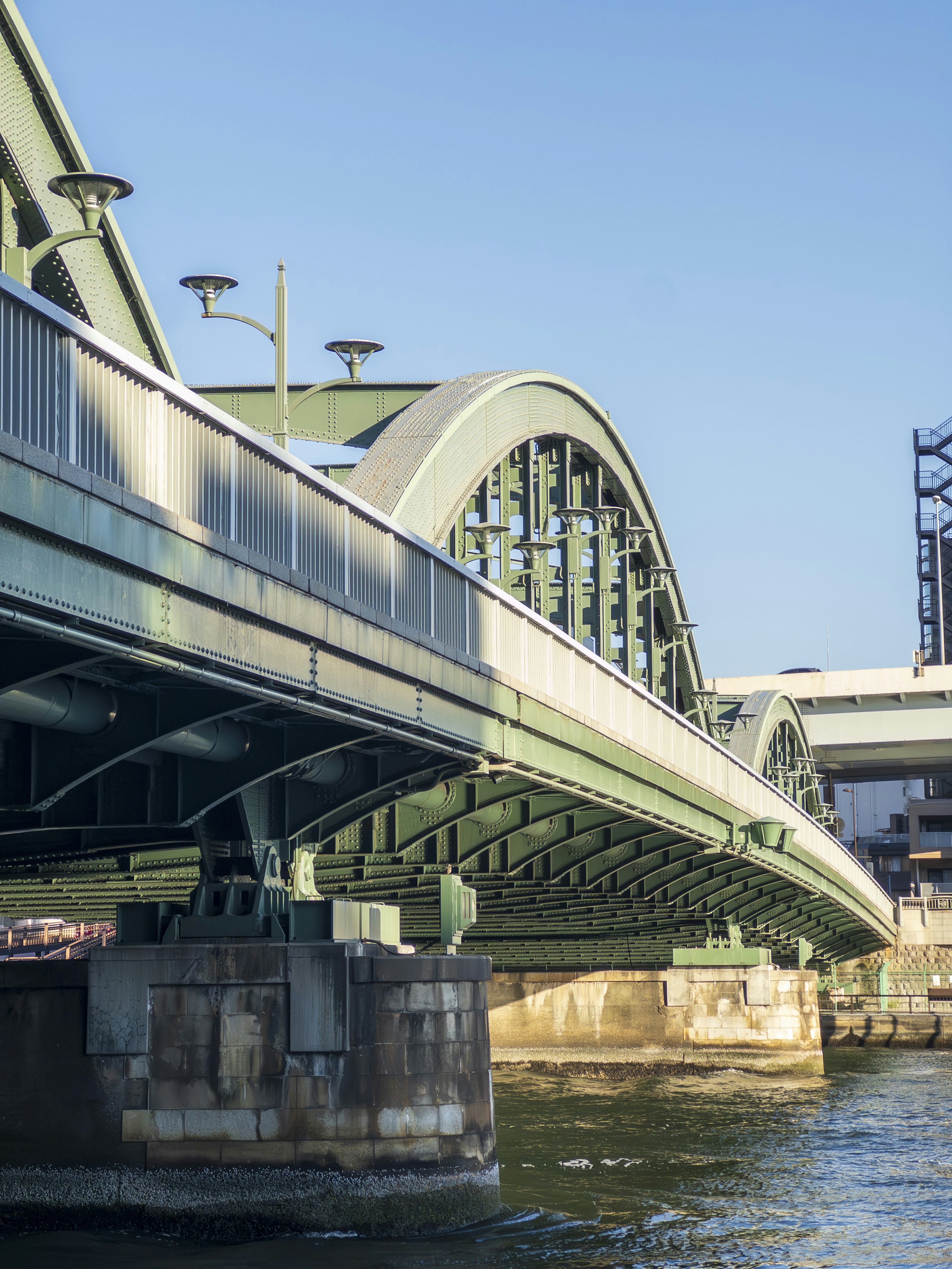 Blick von unten auf eine schöne Bogenbrücke mit klarem blauen Himmel und Wasser