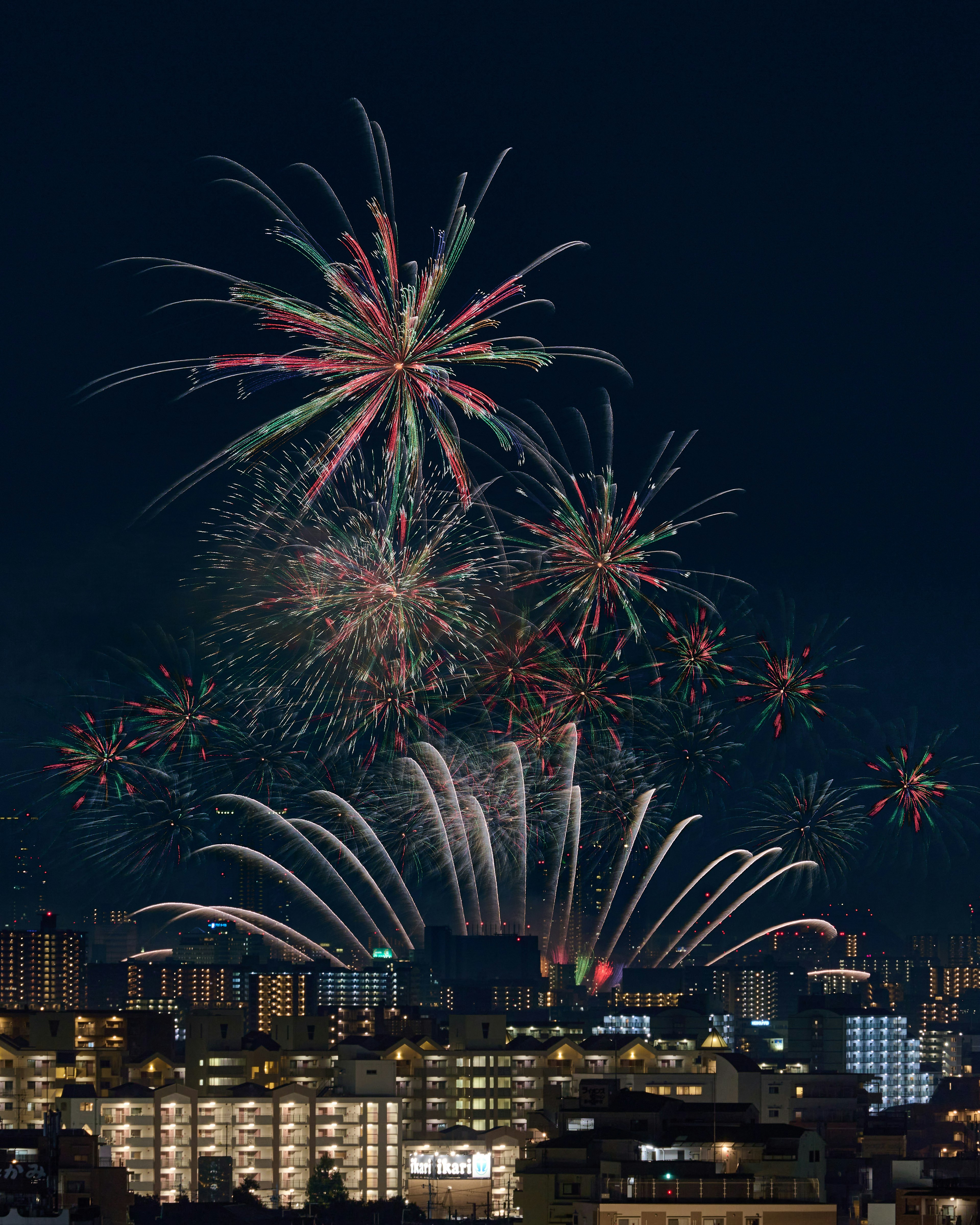 五彩繽紛的煙花在夜空中綻放，背景是城市景觀