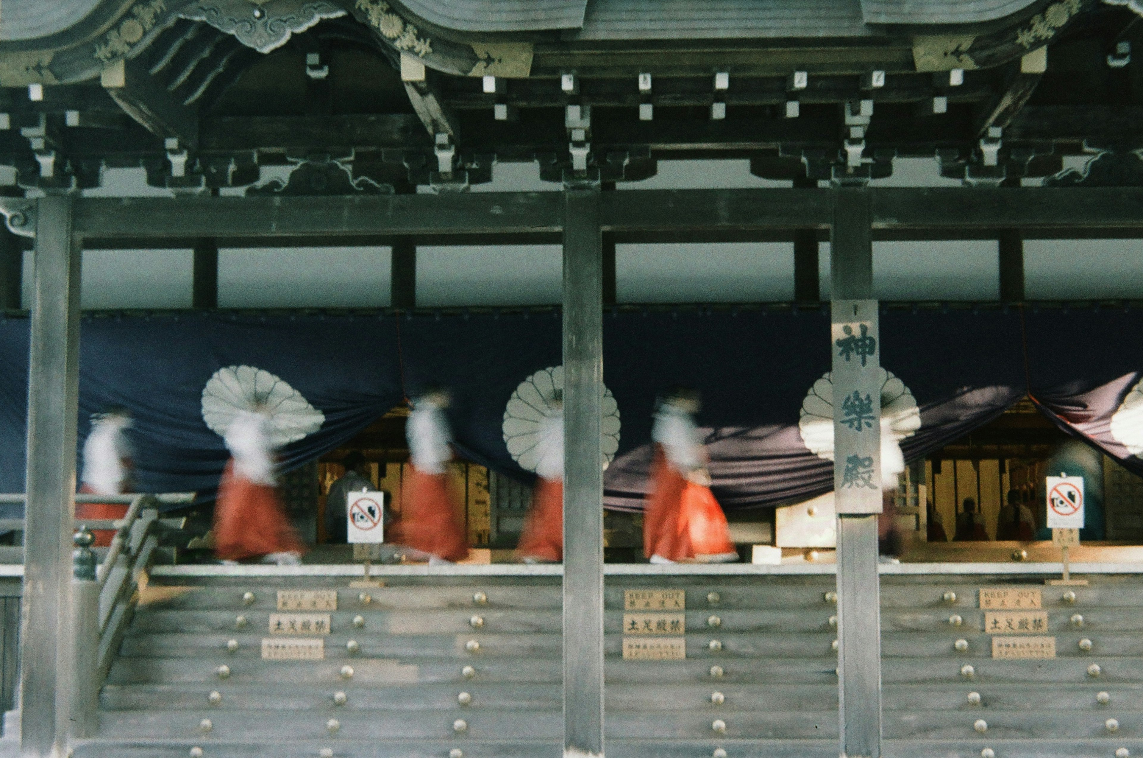 Women in red garments walking in a shrine courtyard