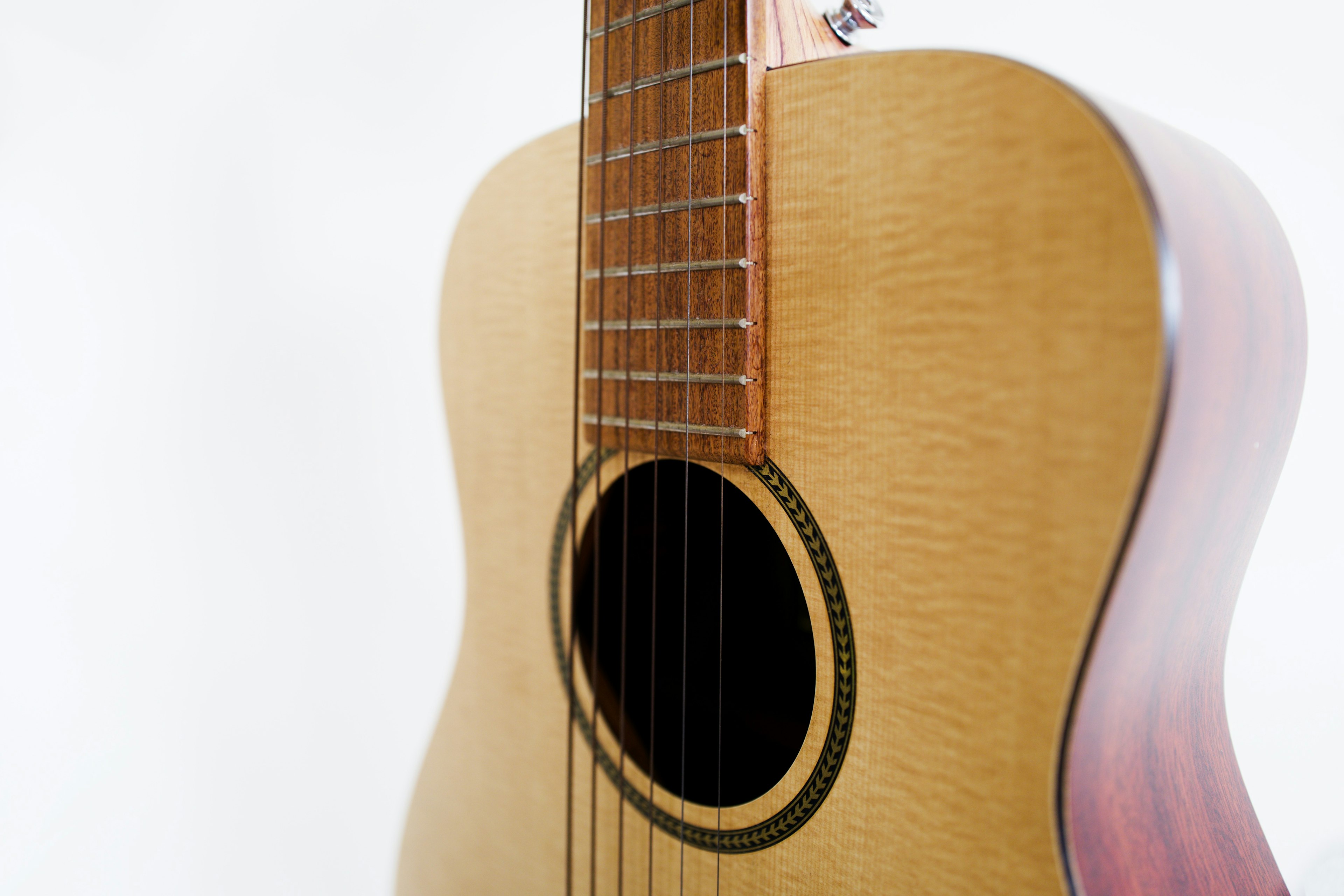 Nahaufnahme einer Akustikgitarre mit Holzgehäuse und schwarzem Schallloch