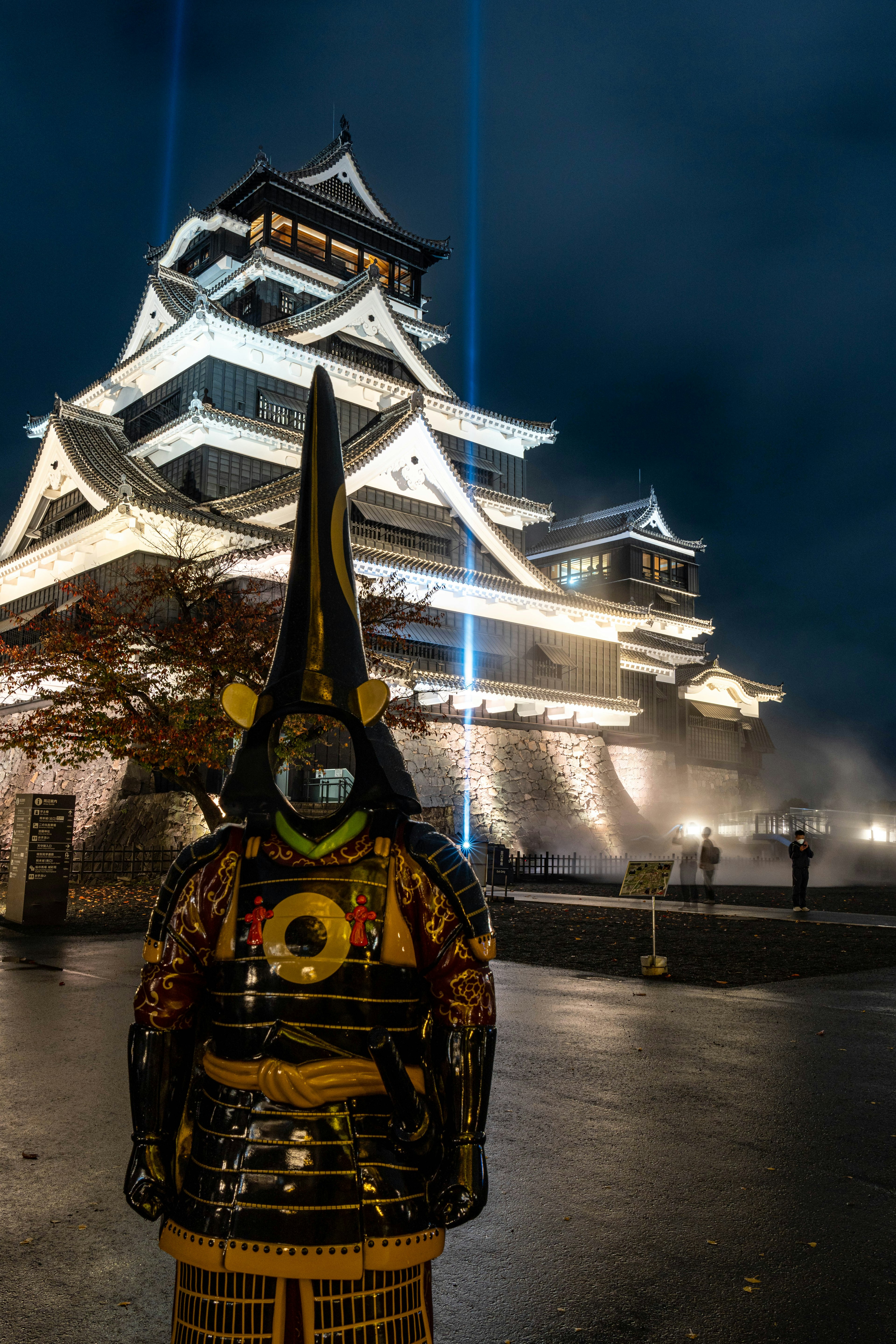 夜の熊本城と伝統的な衣装を着た武士