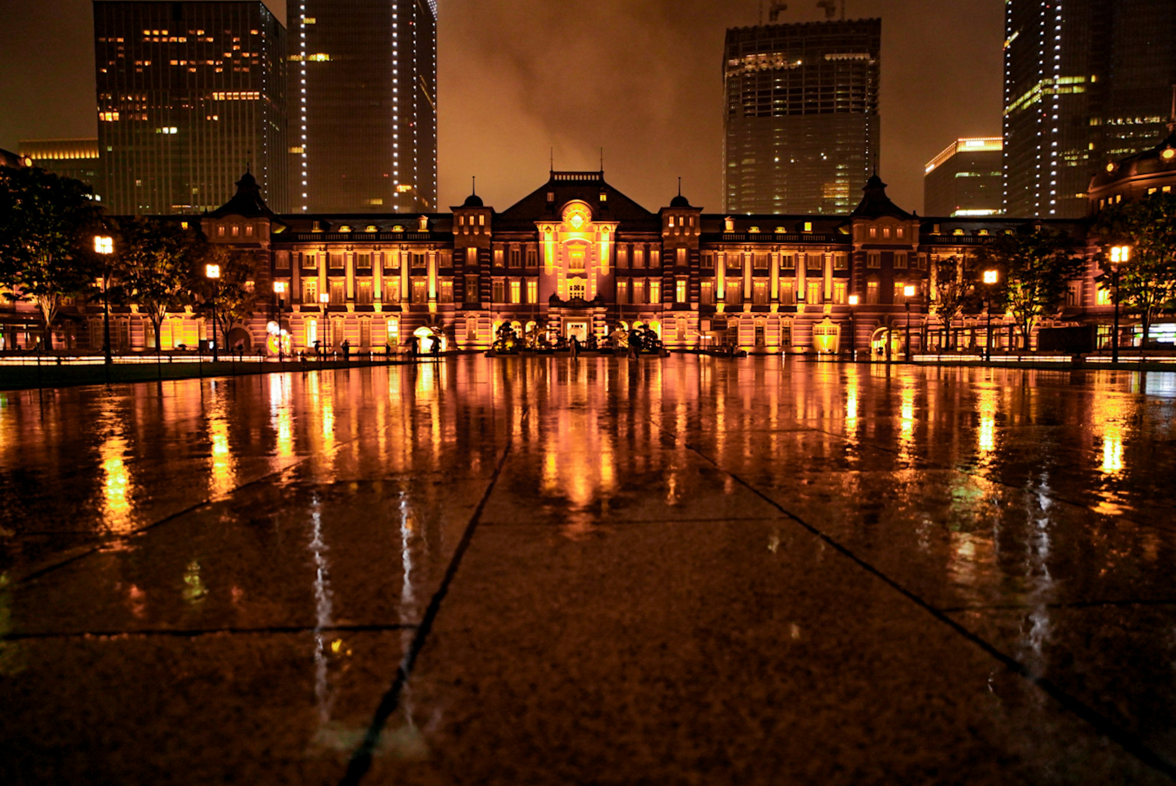 Arsitektur indah Stasiun Tokyo di malam hari dengan refleksi di genangan air