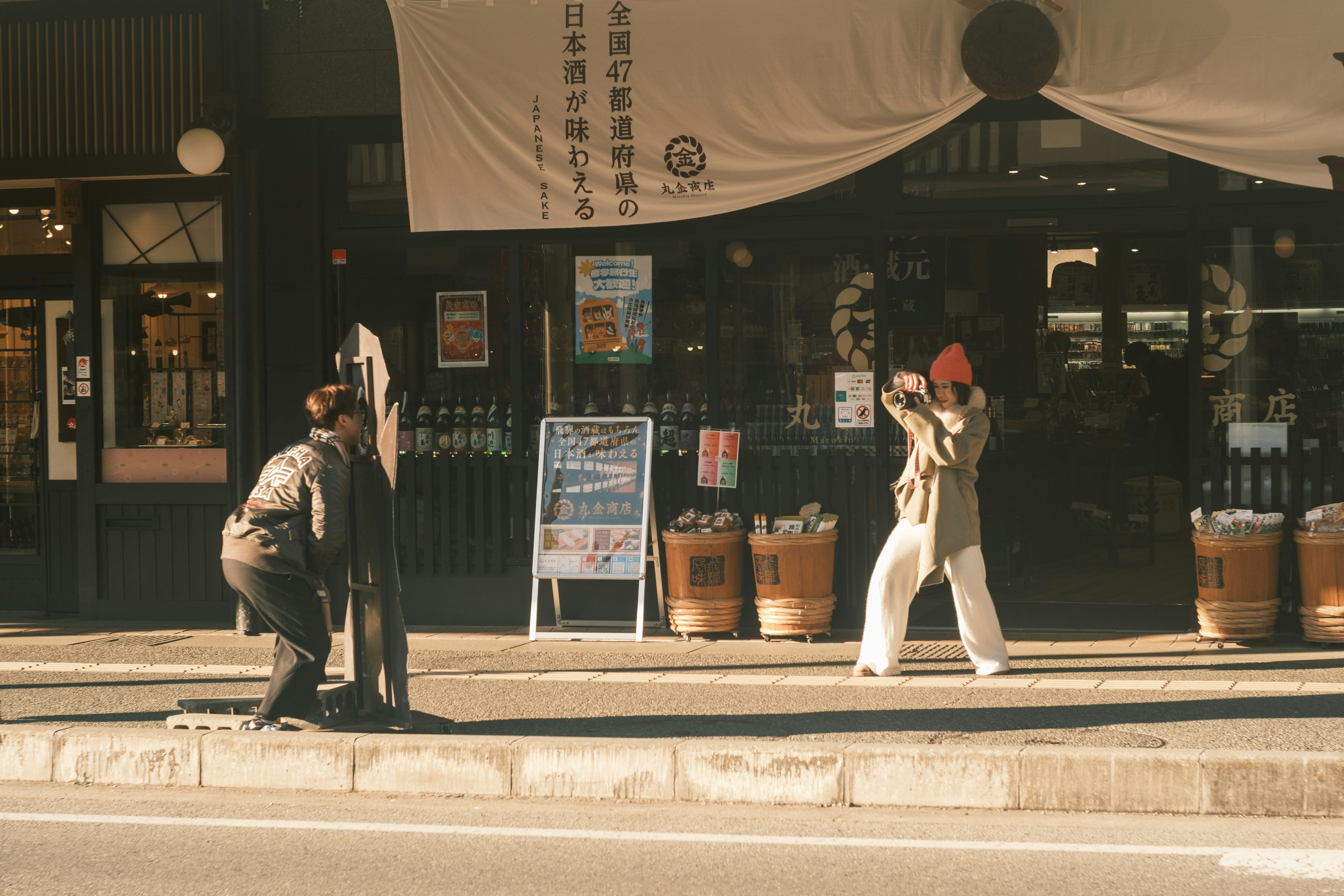 Dos personas frente a una tienda en la calle con un toldo tradicional