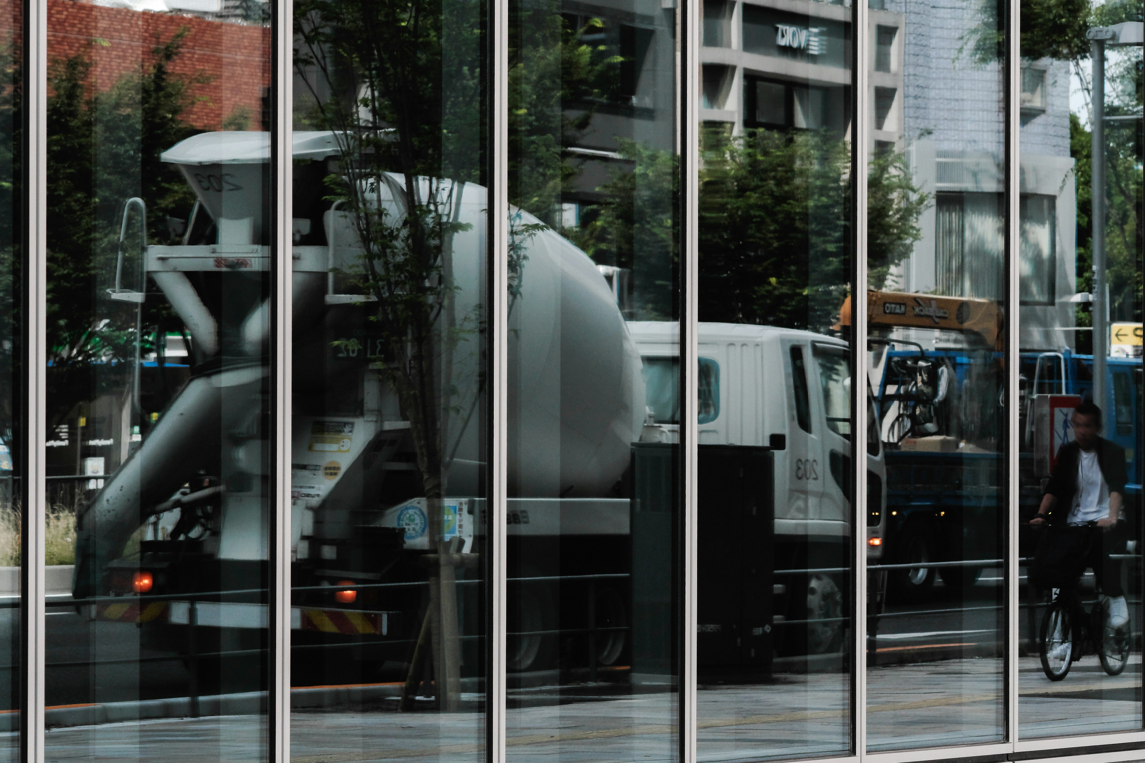 Camion malaxeur à béton reflété dans le verre avec paysage urbain