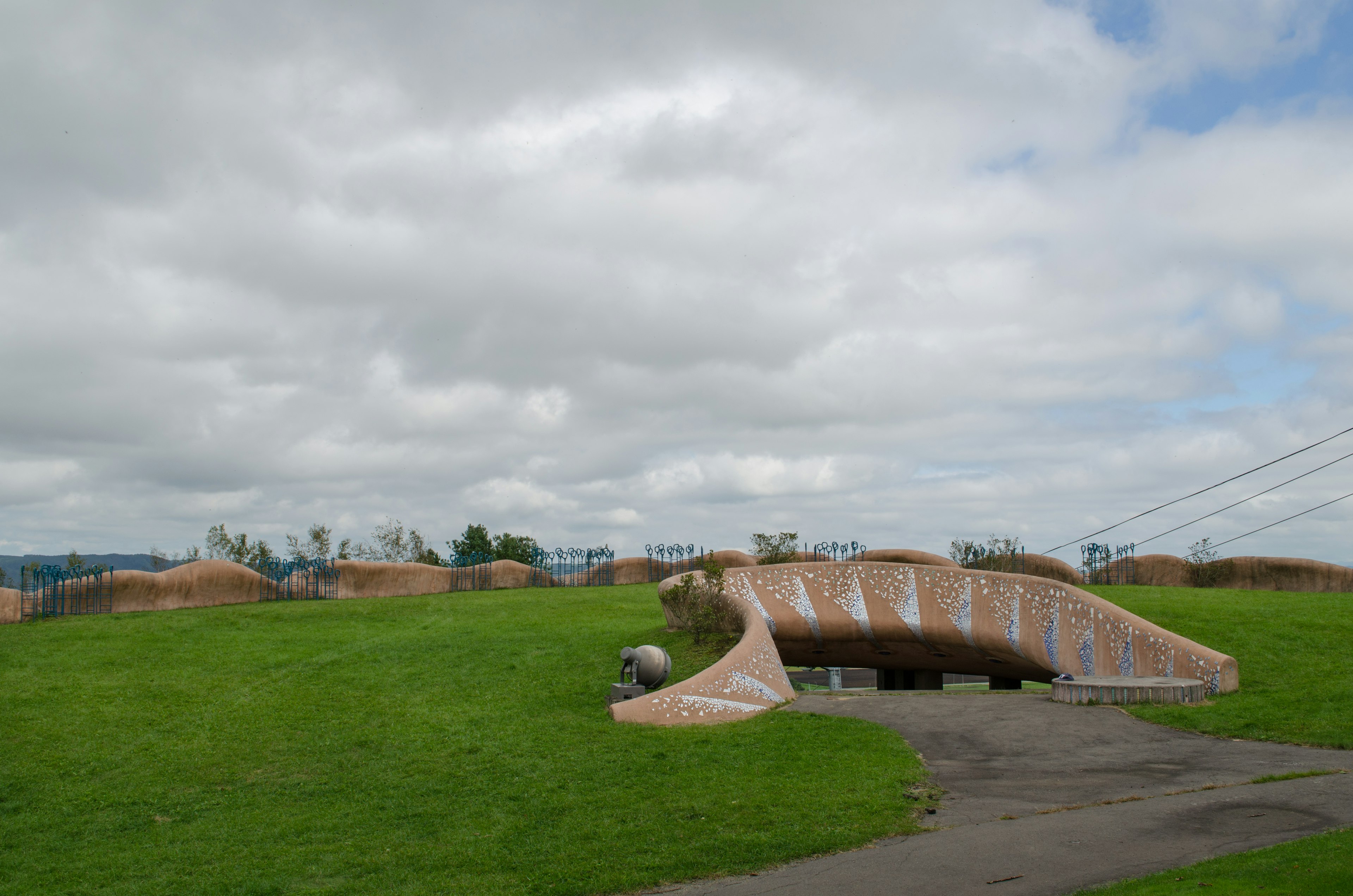 Structure de forme unique sur une pelouse verte sous un ciel nuageux