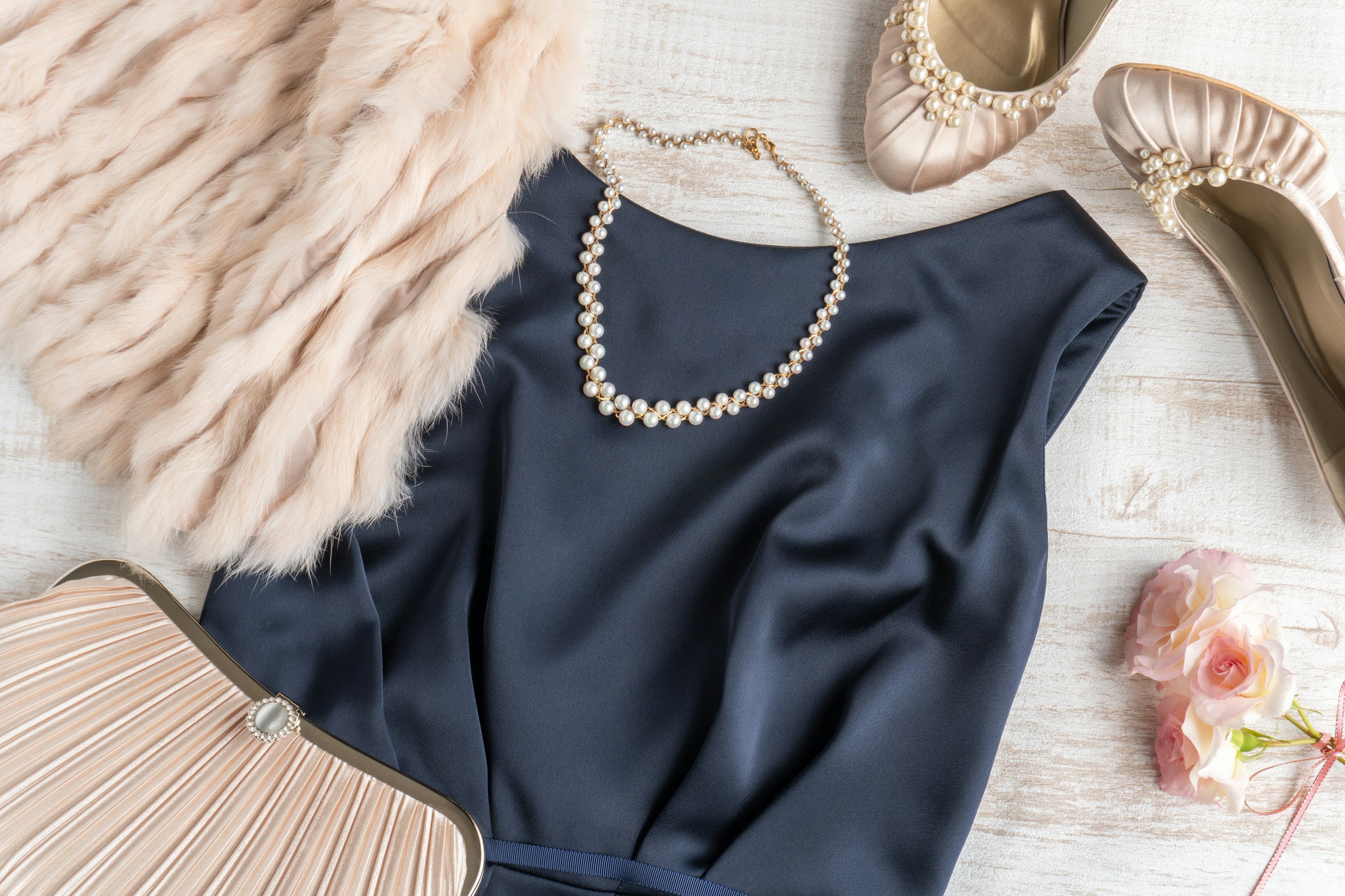 Composizione elegante con un abito blu navy una collana di perle e accessori chic