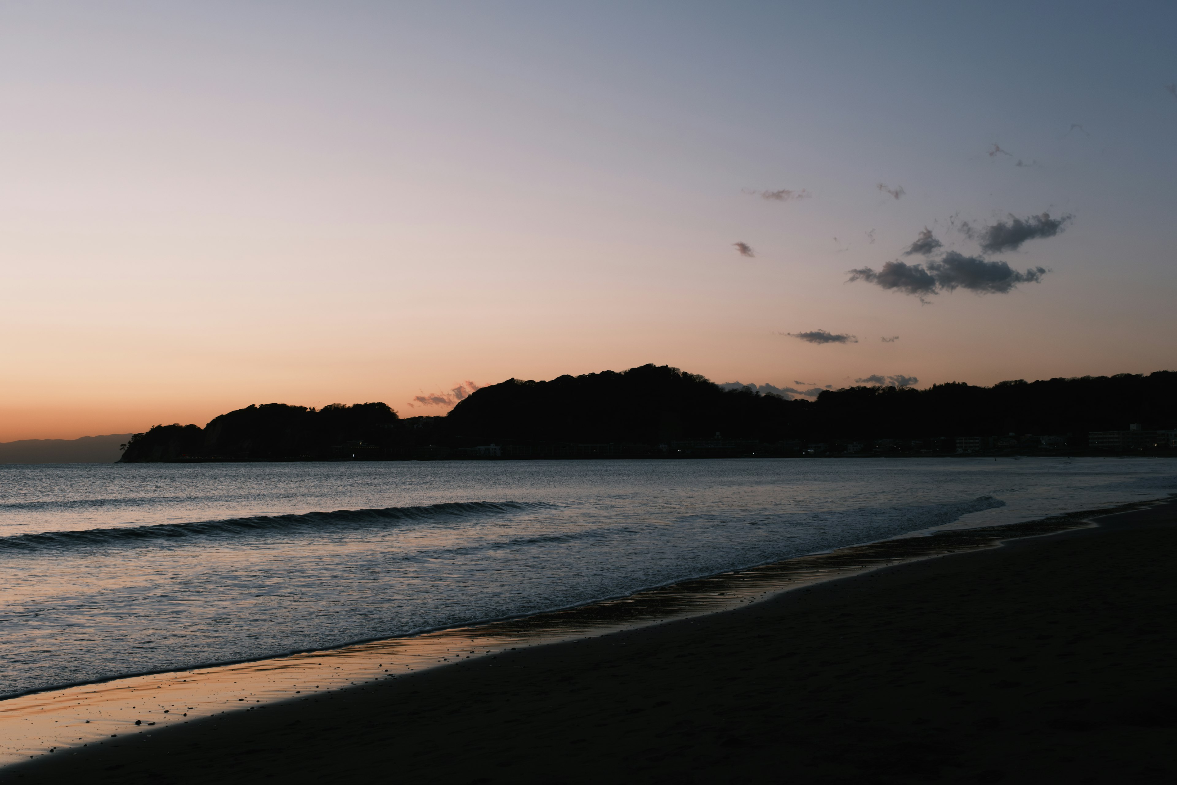 日落时的海岸轮廓与温和的波浪