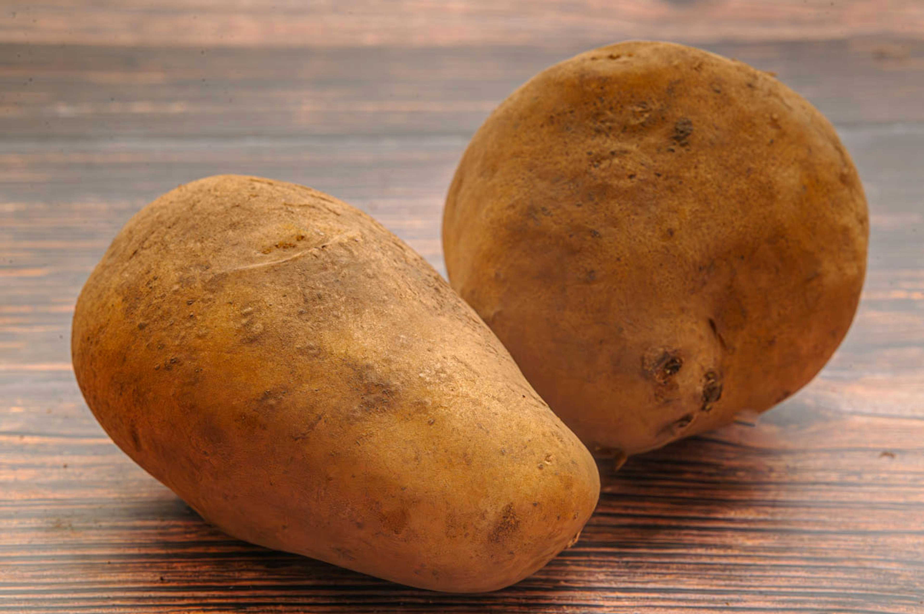 Two potatoes on a wooden table