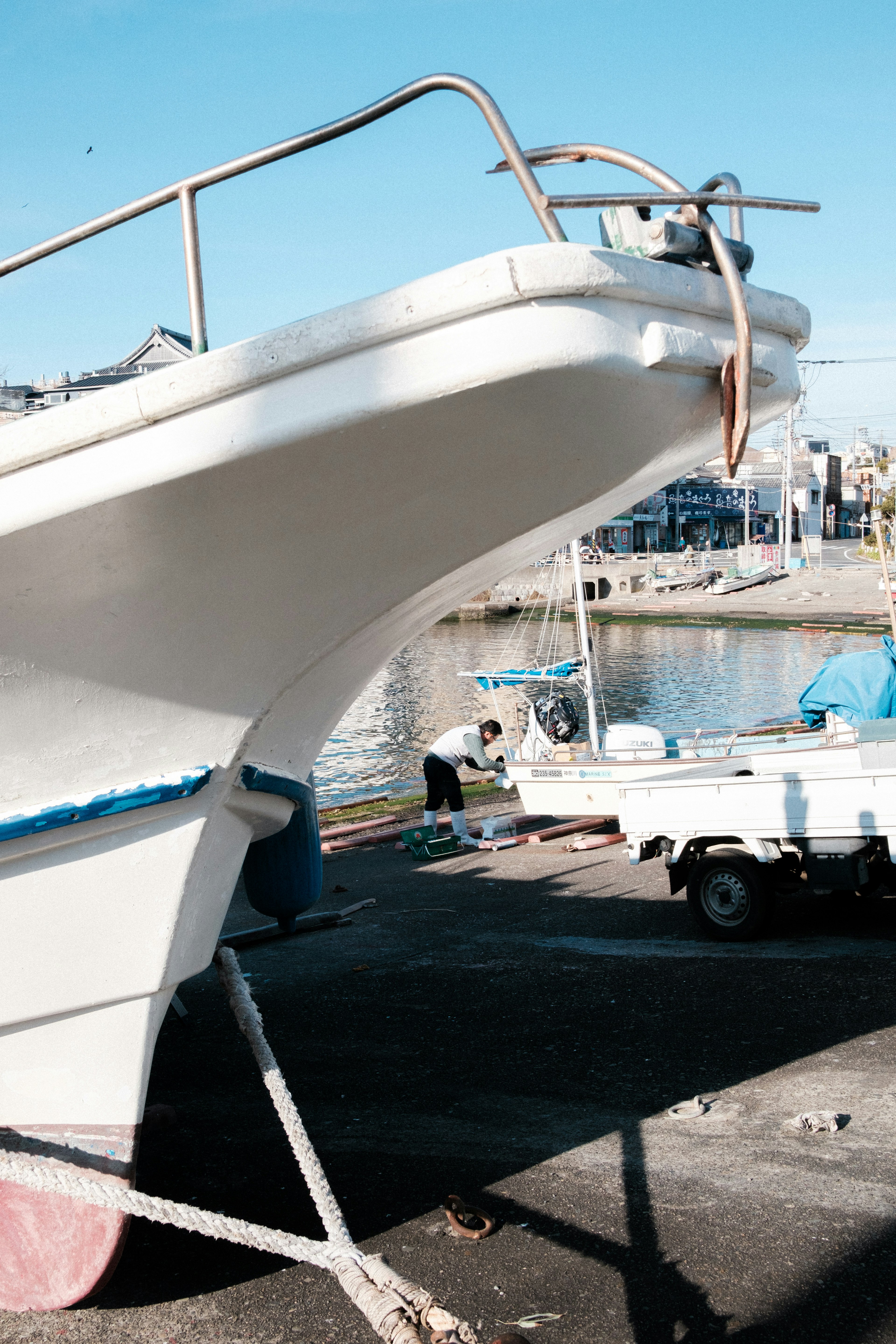 Proa de un barco con una persona trabajando en un puerto