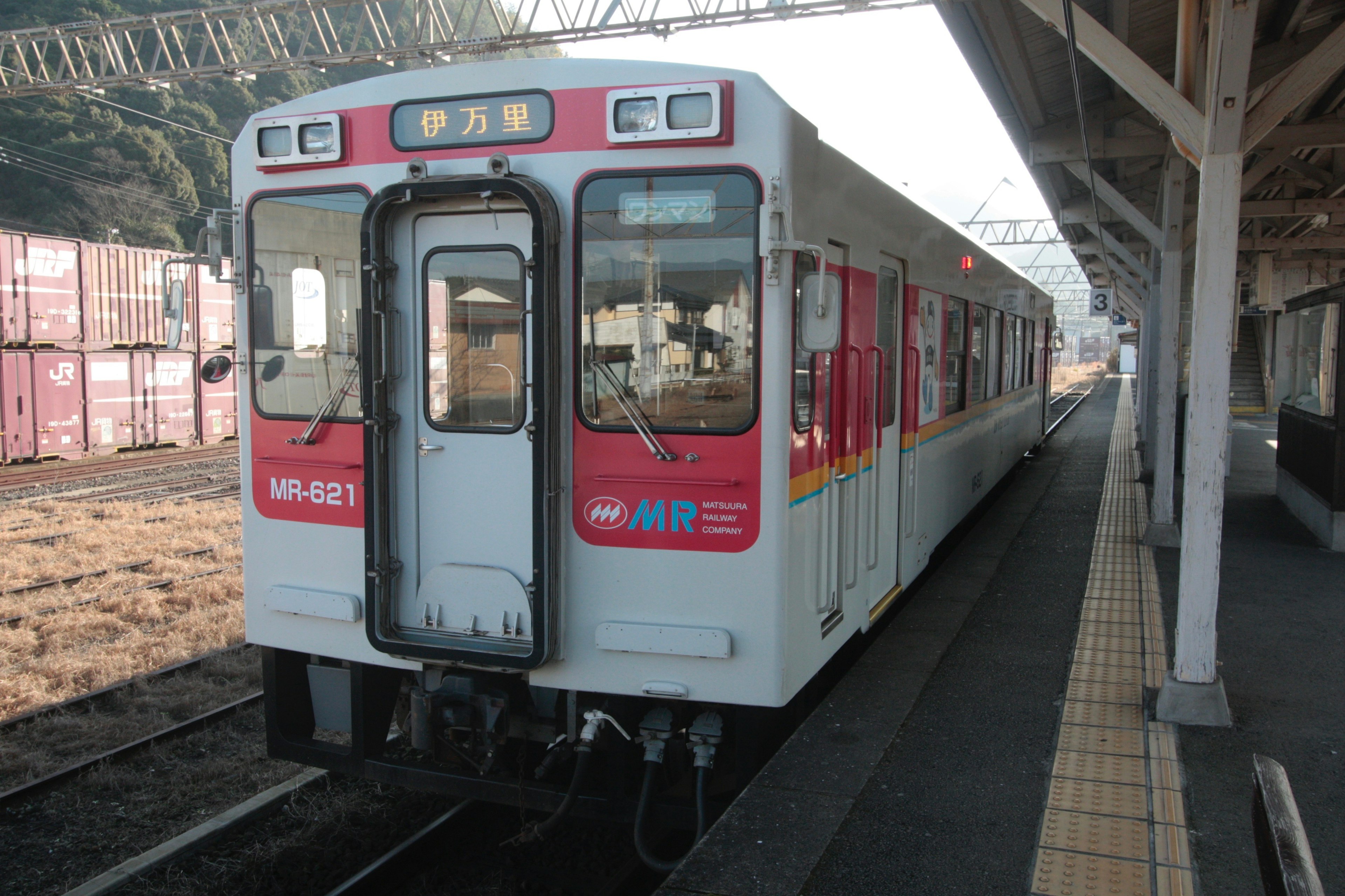 Train blanc avec des rayures rouges garé à une station