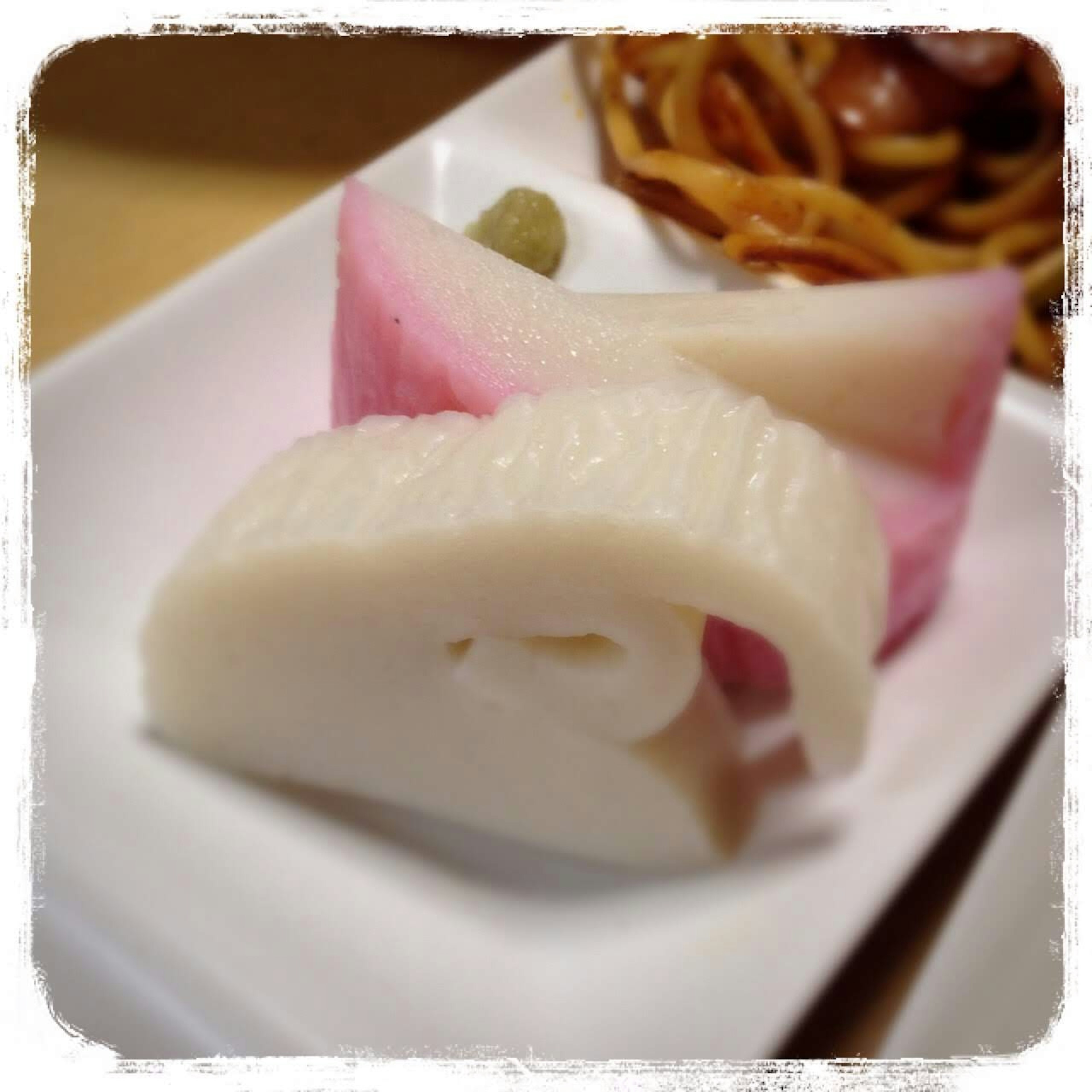 Sliced white fish paste and pink fish paste arranged on a plate