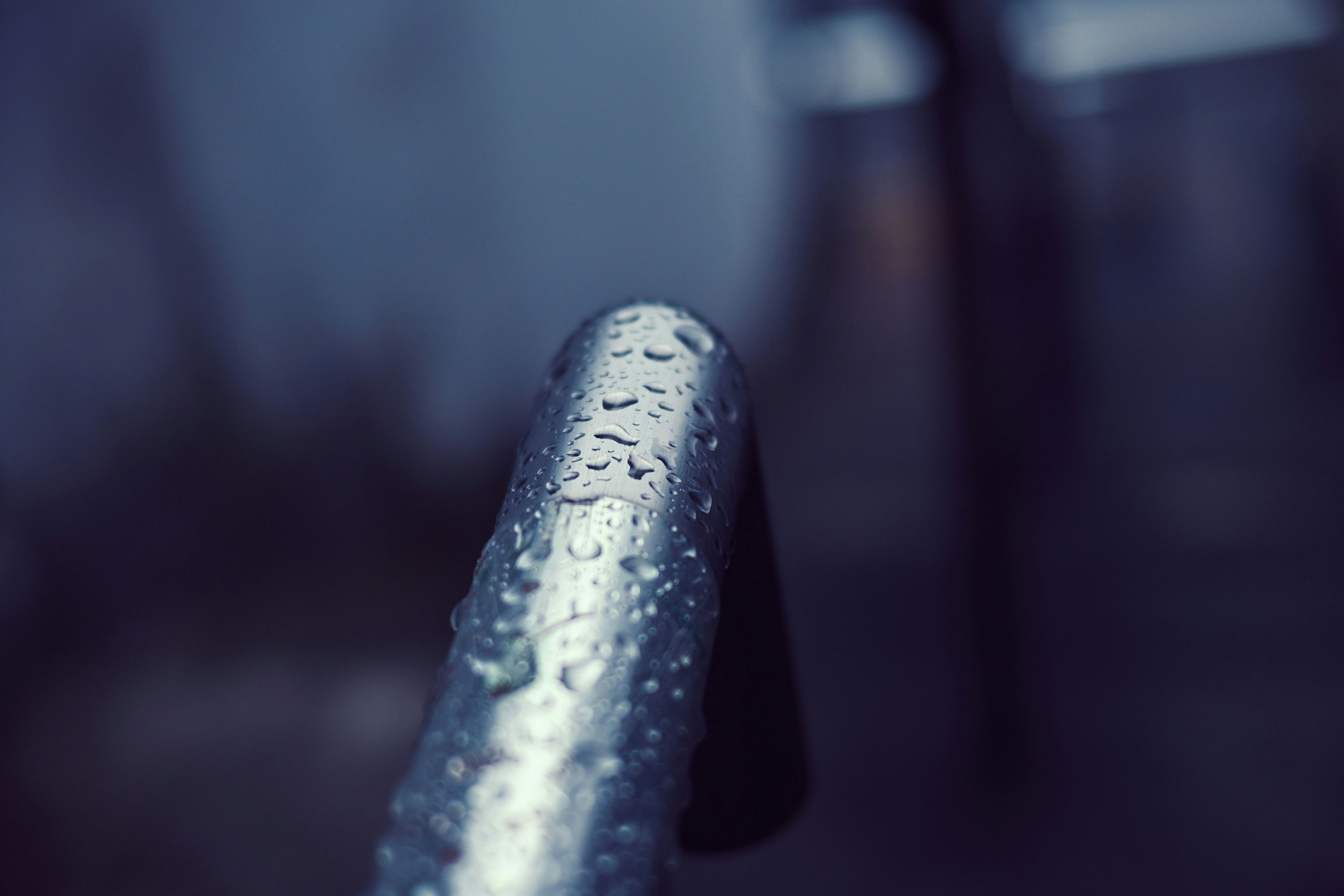 Close-up of a metal railing covered in raindrops