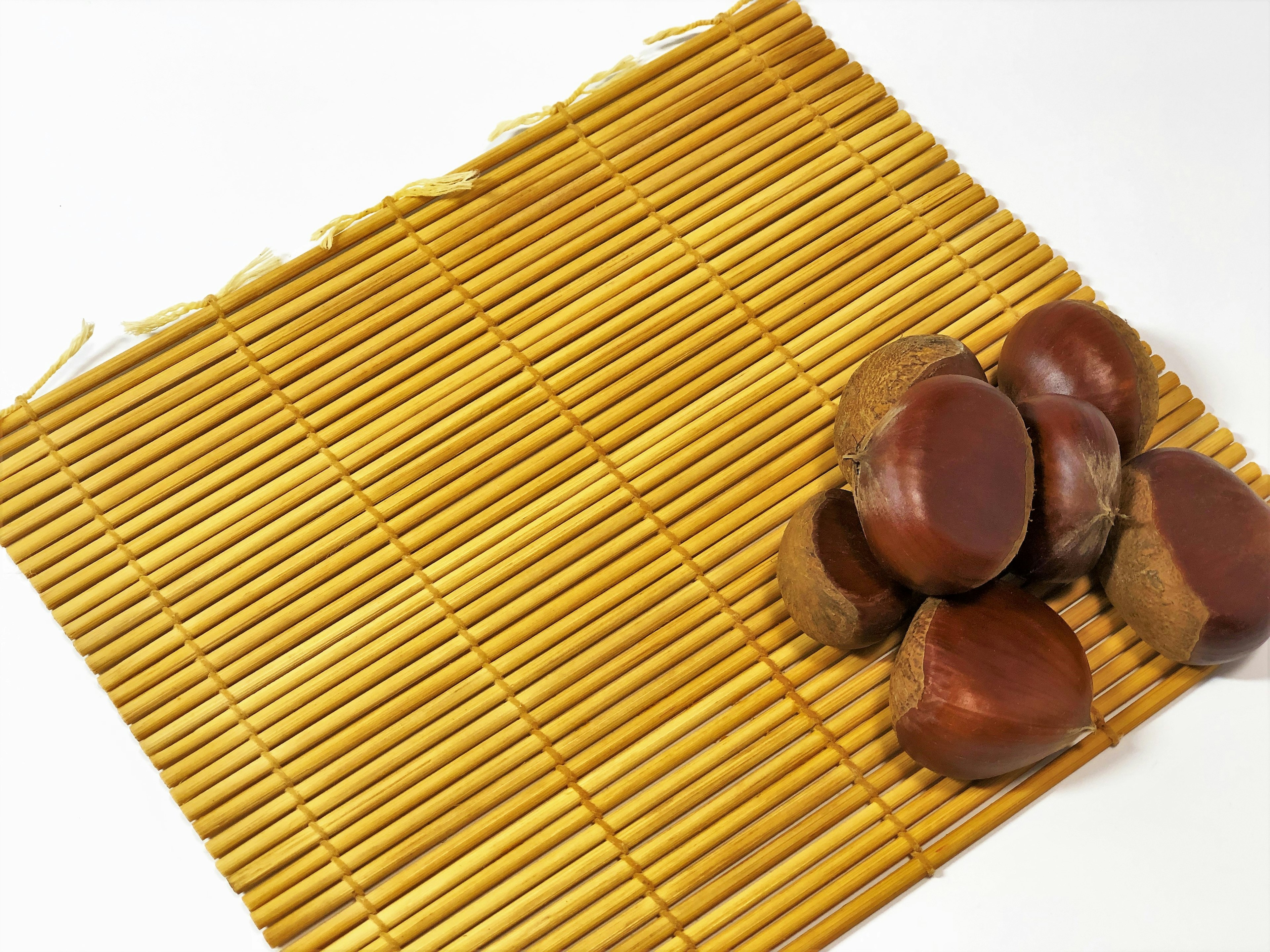 A group of chestnuts on a bamboo mat