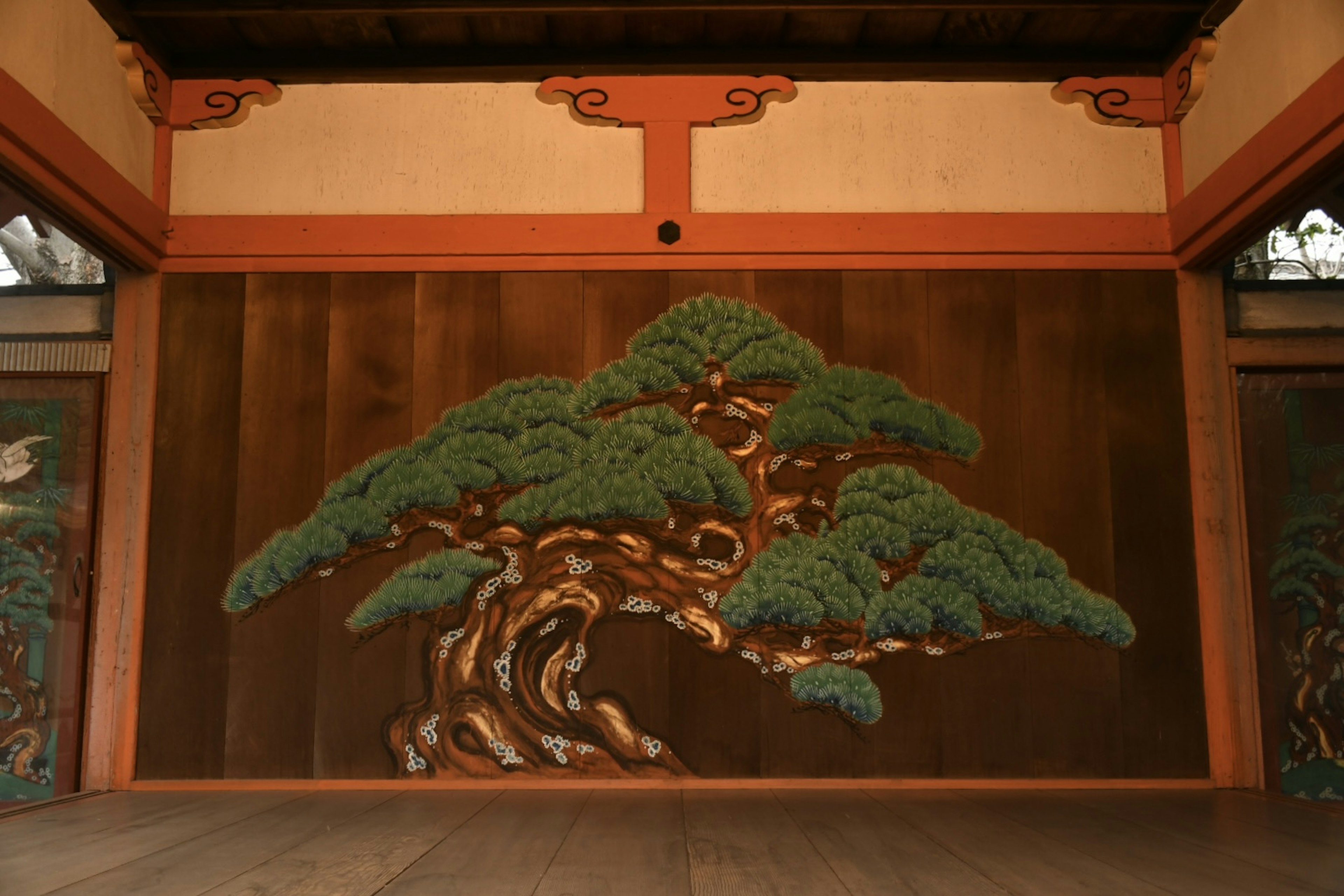 Interior bangunan tradisional Jepang dengan mural besar pohon pinus