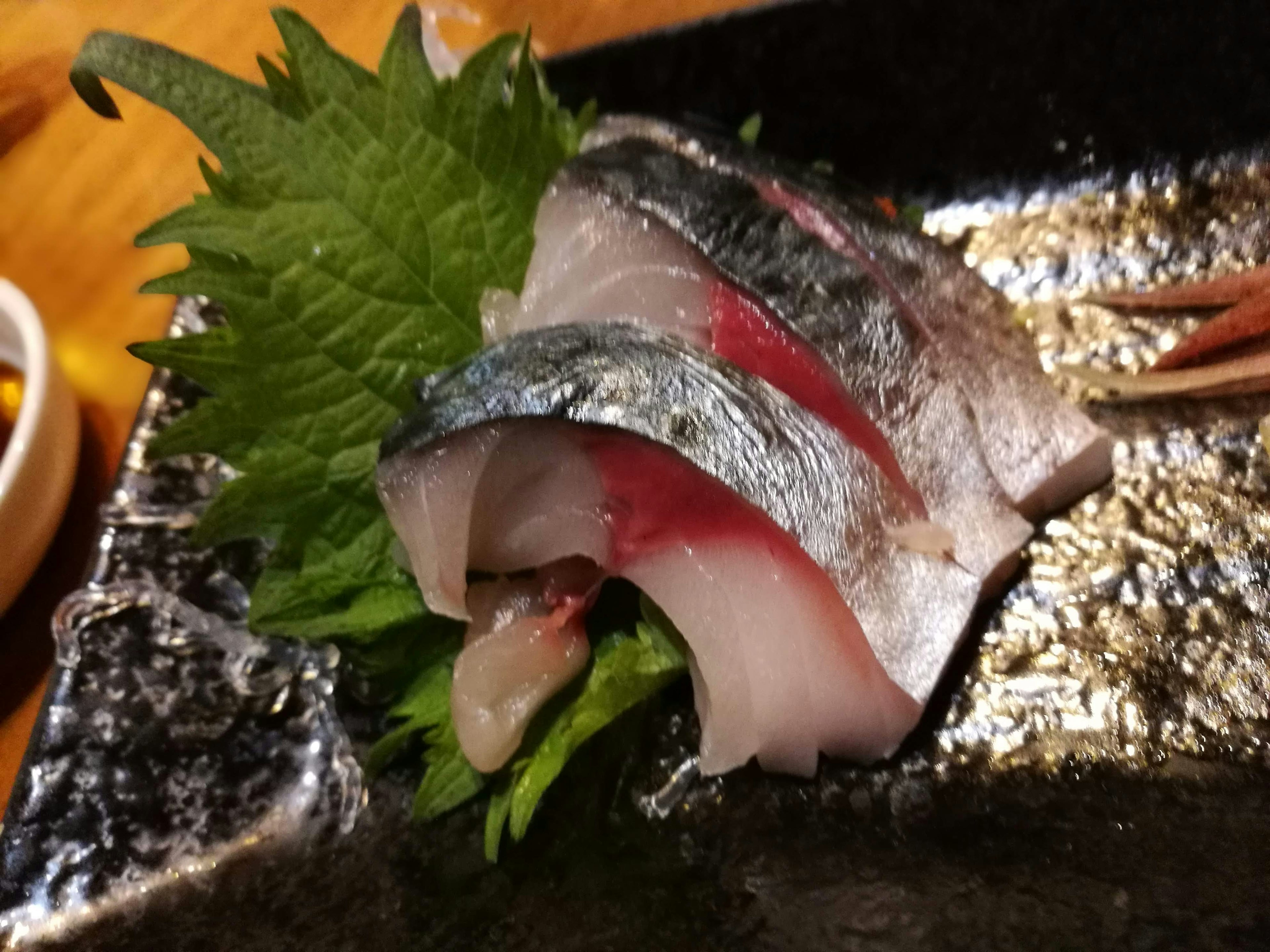 Fresh sashimi served on a plate with green leaves