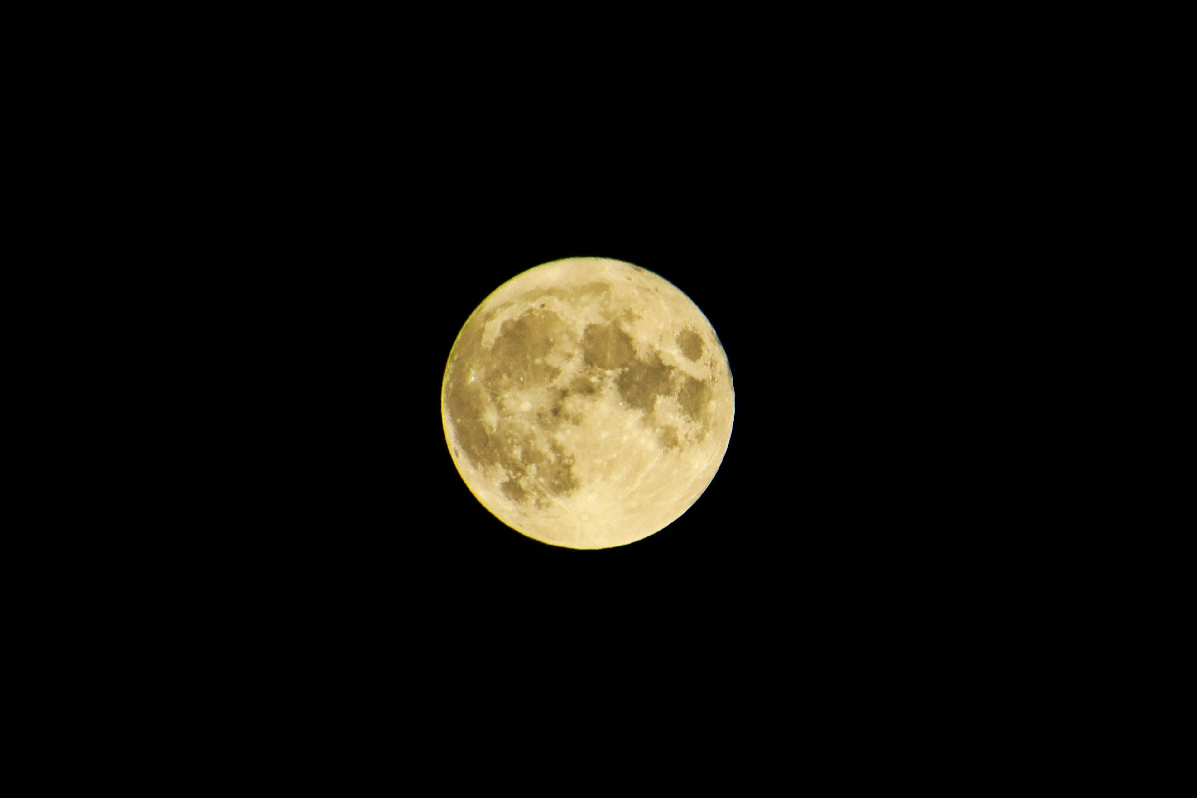 Luna llena amarilla brillante sobre un fondo negro