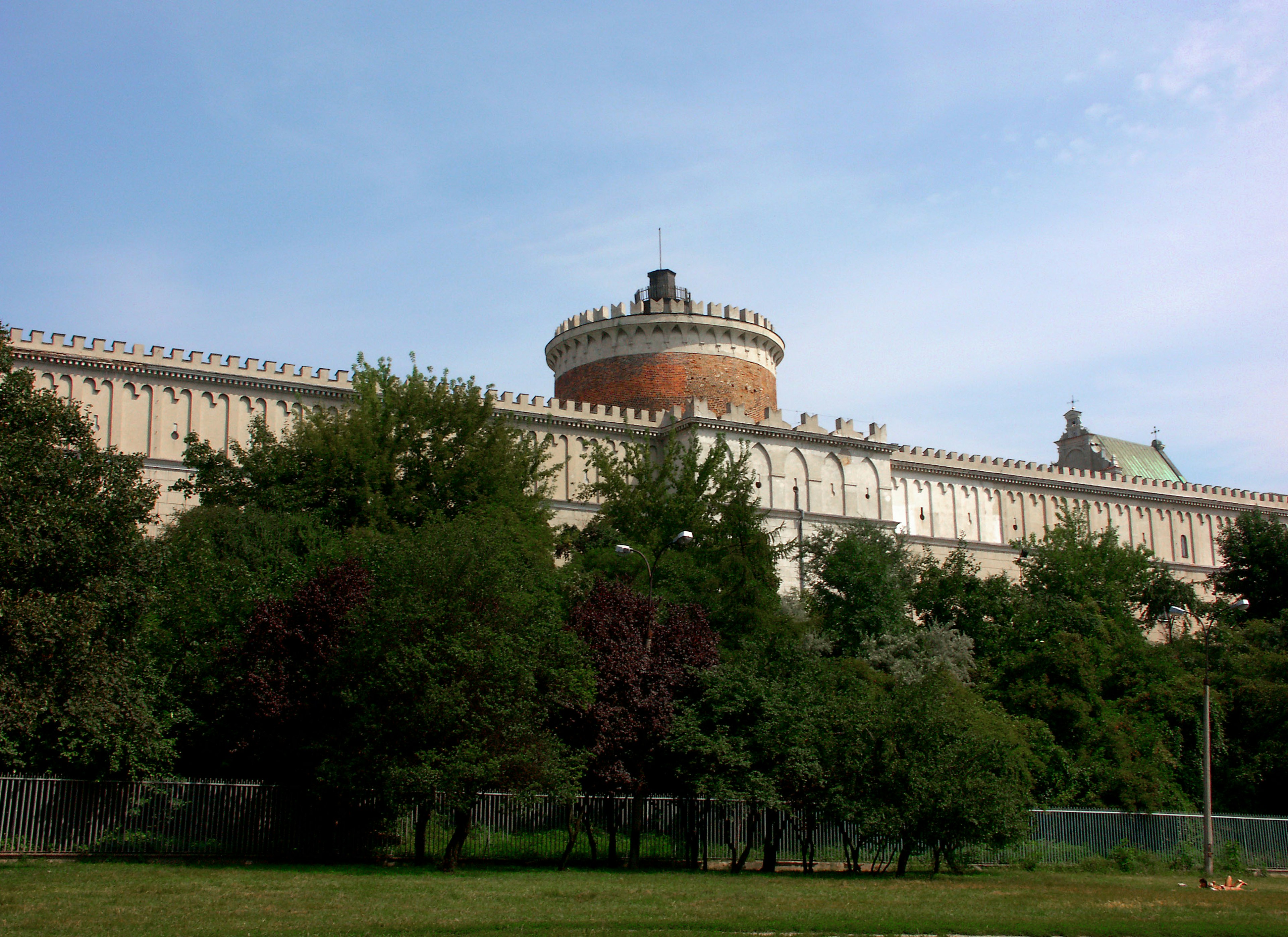 Bâtiment historique entouré de verdure avec une tour ronde proéminente