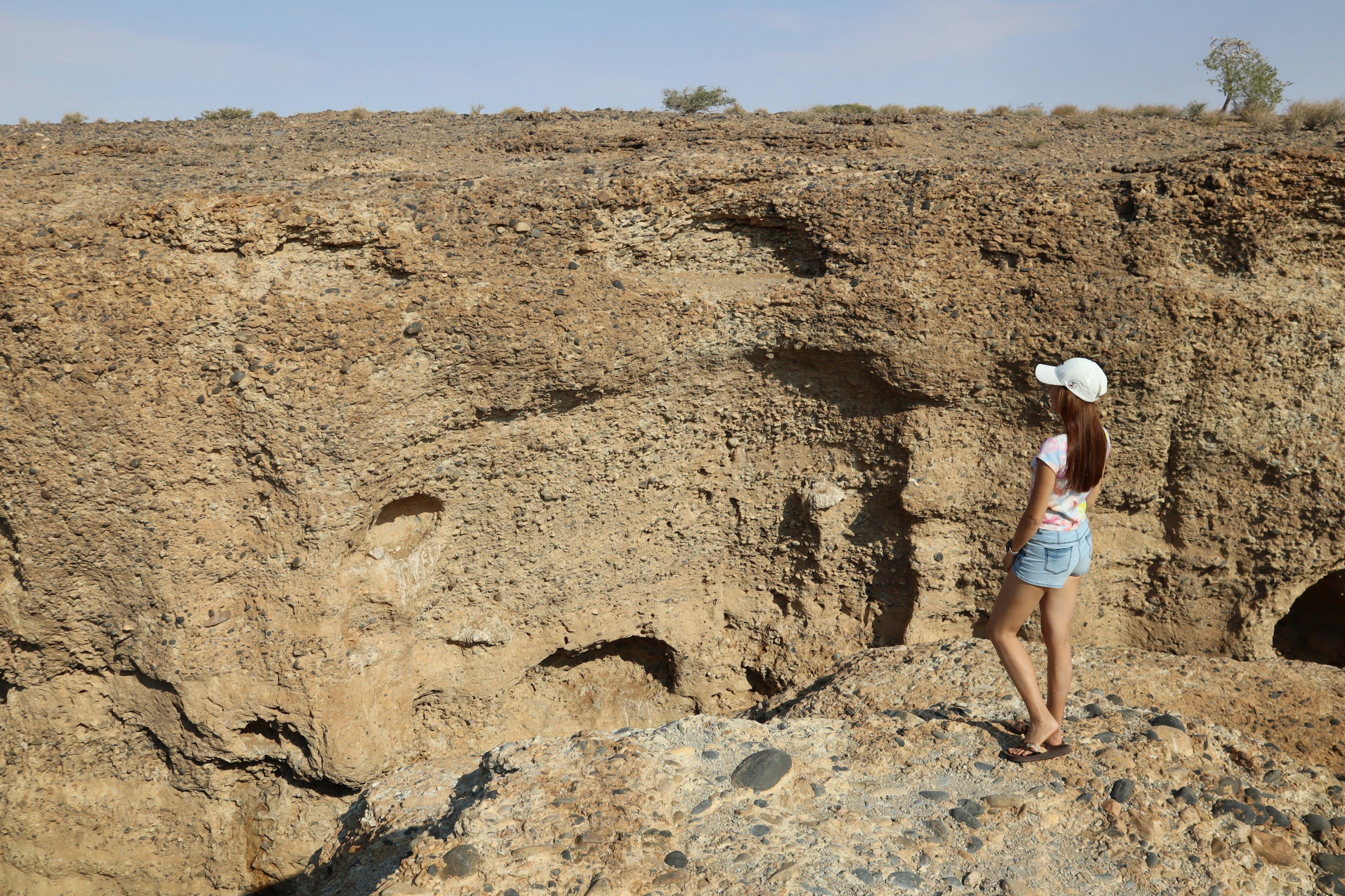 Woman standing on rocky terrain with dry brown landscape