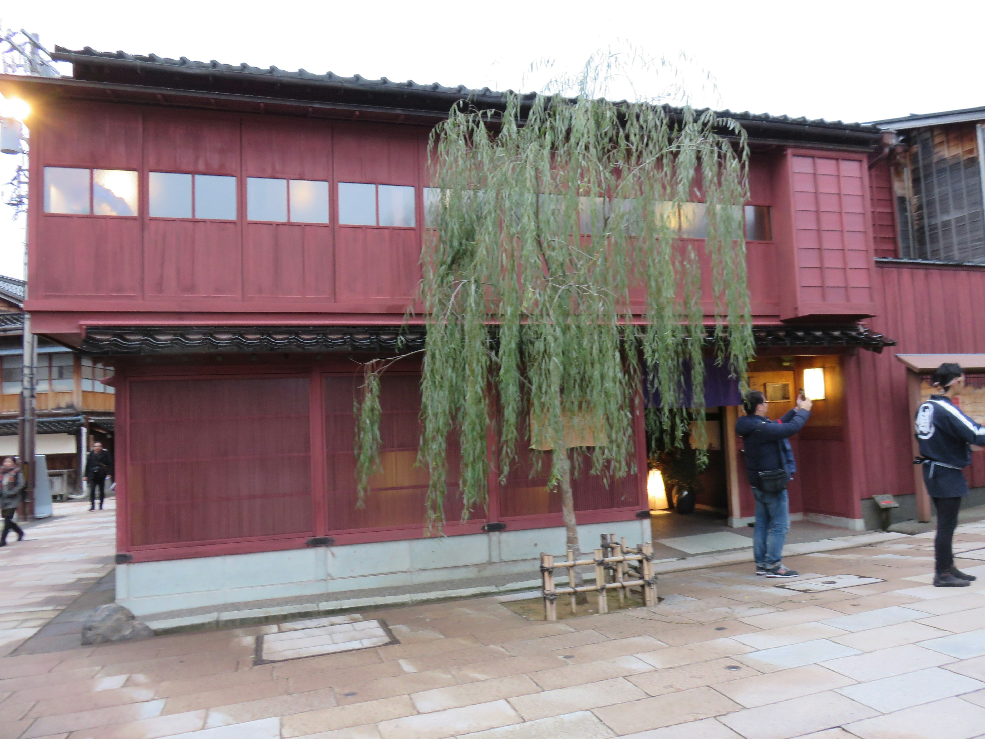 Bâtiment rouge avec un saule pleureur