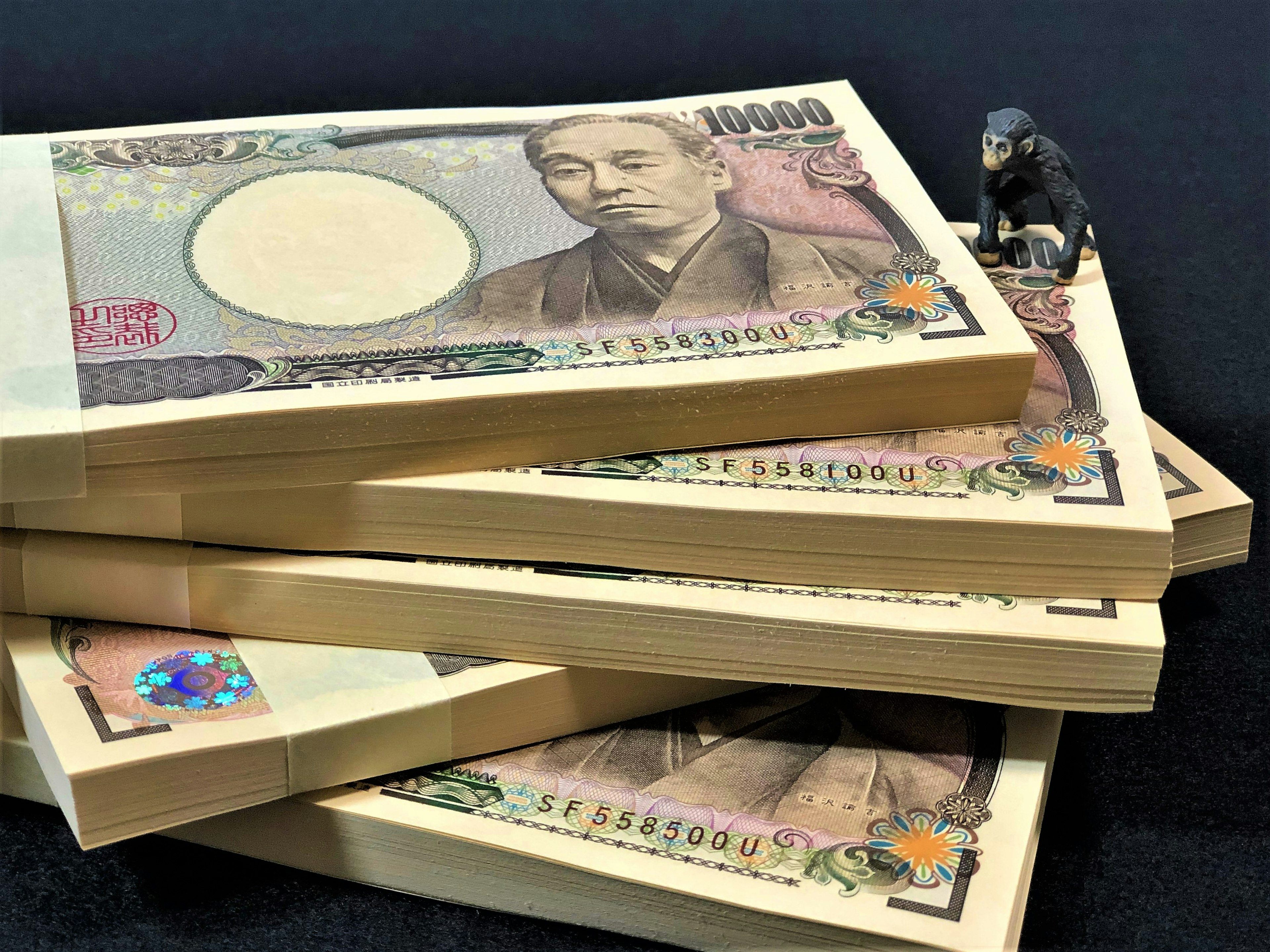 Billetes de yen japonés apilados con una pequeña figura