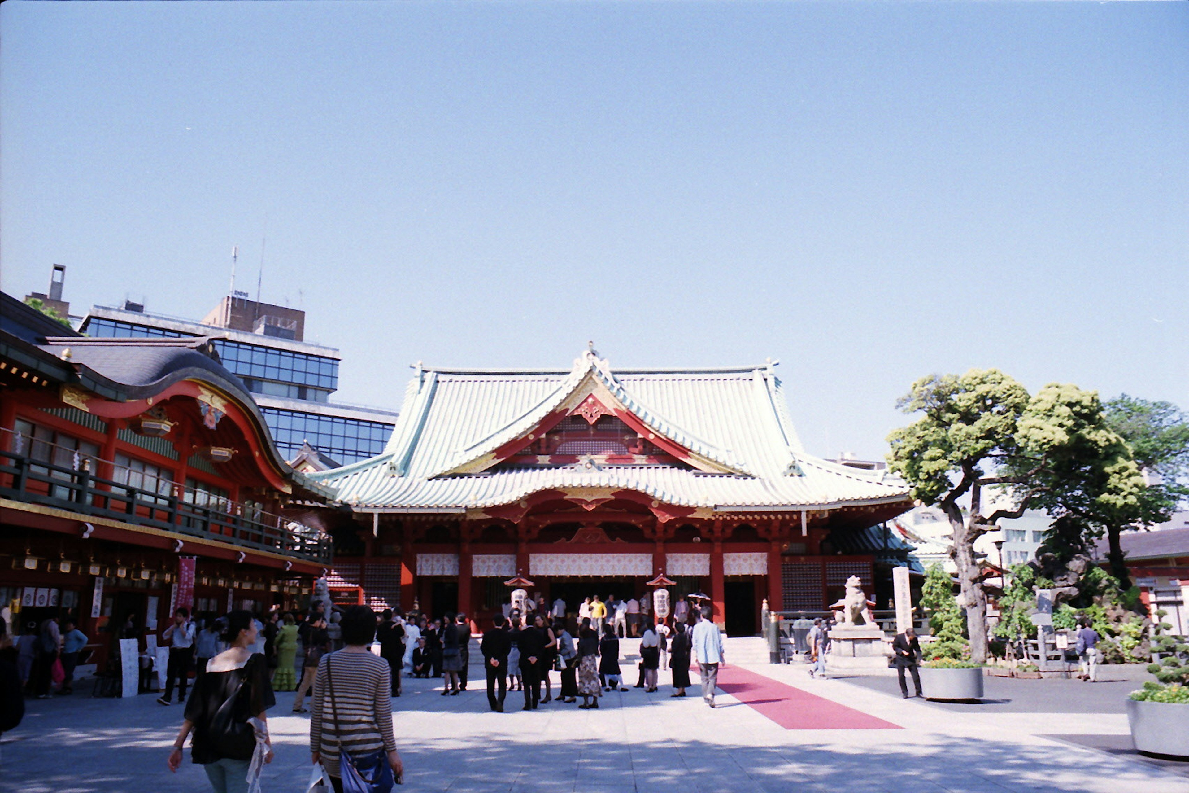 青空の下にある伝統的な日本の神社の建物と訪問者たち