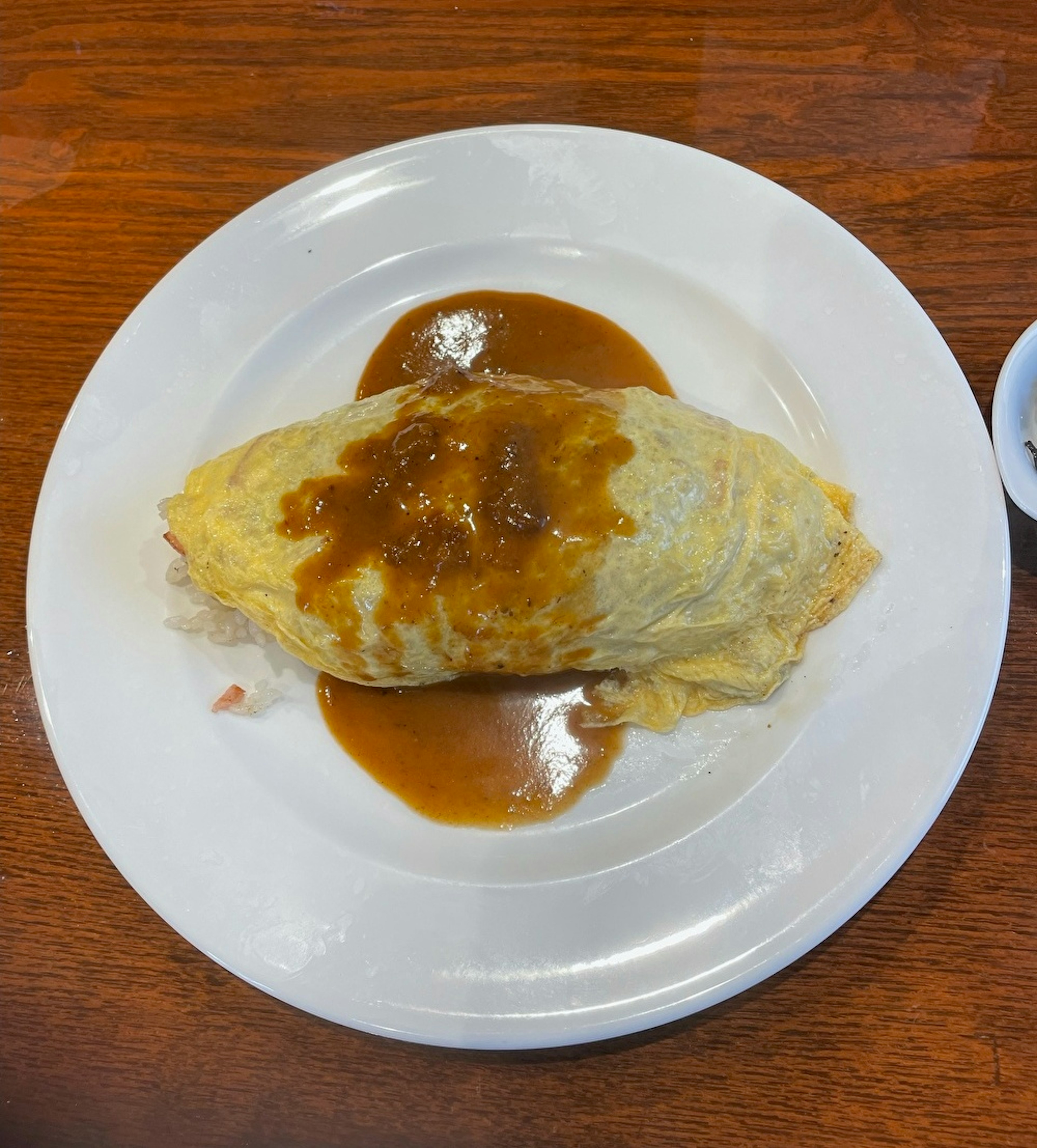 Omelet nasi dengan saus gravy di atas piring putih