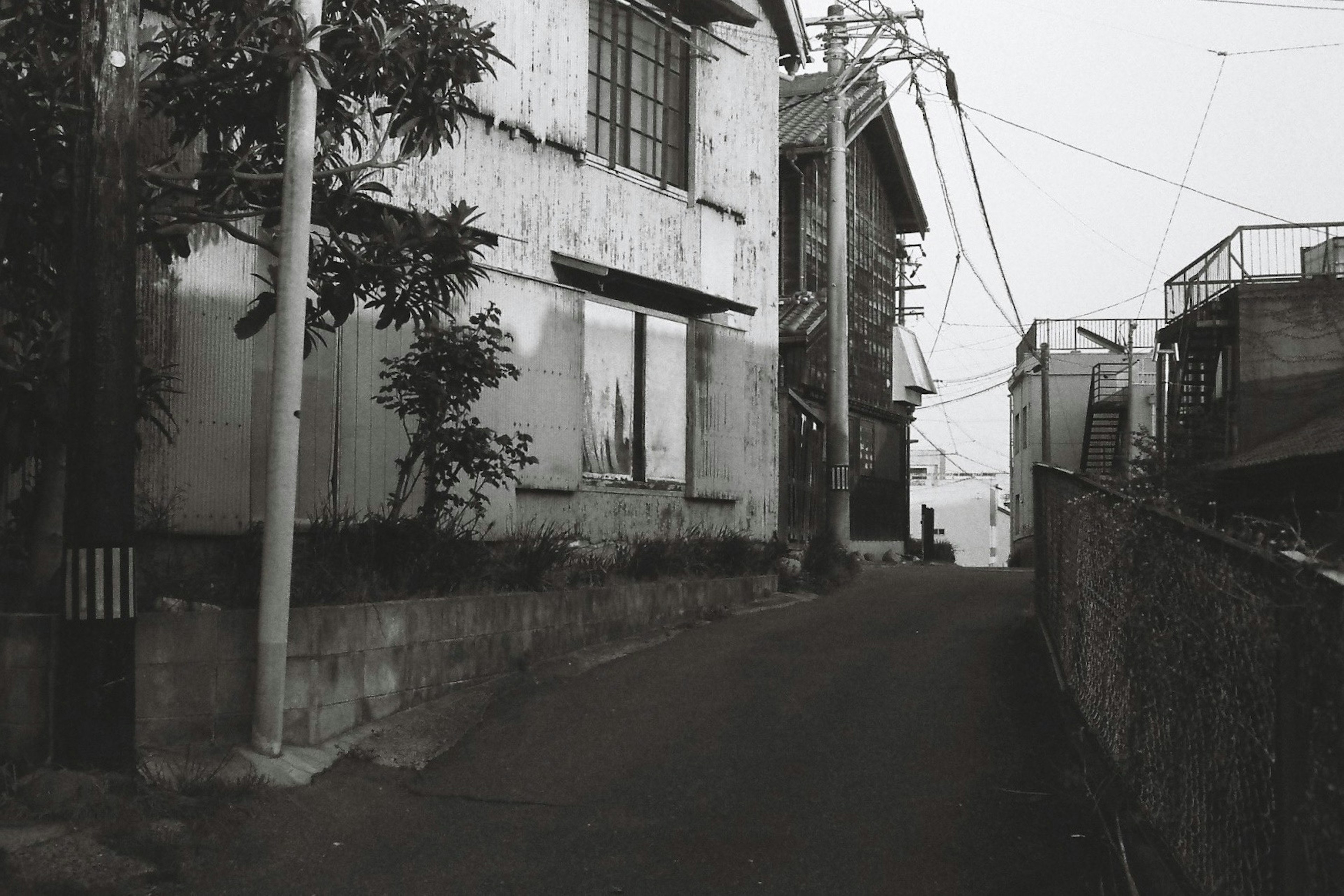 狭い路地に沿った古い建物と電線の風景