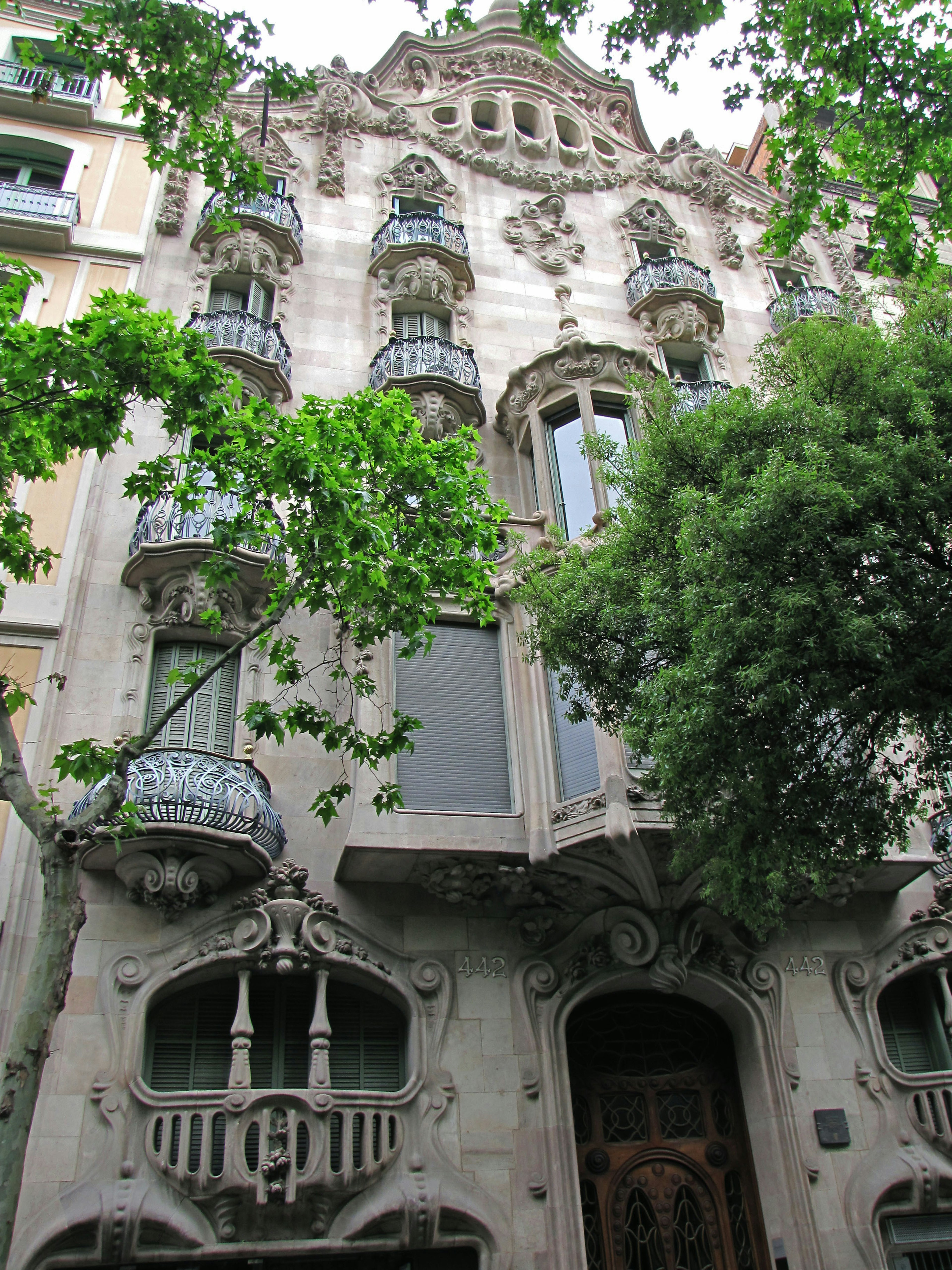 Fasad indah bangunan Barcelona dengan desain Art Nouveau, balkon, dan patung dekoratif