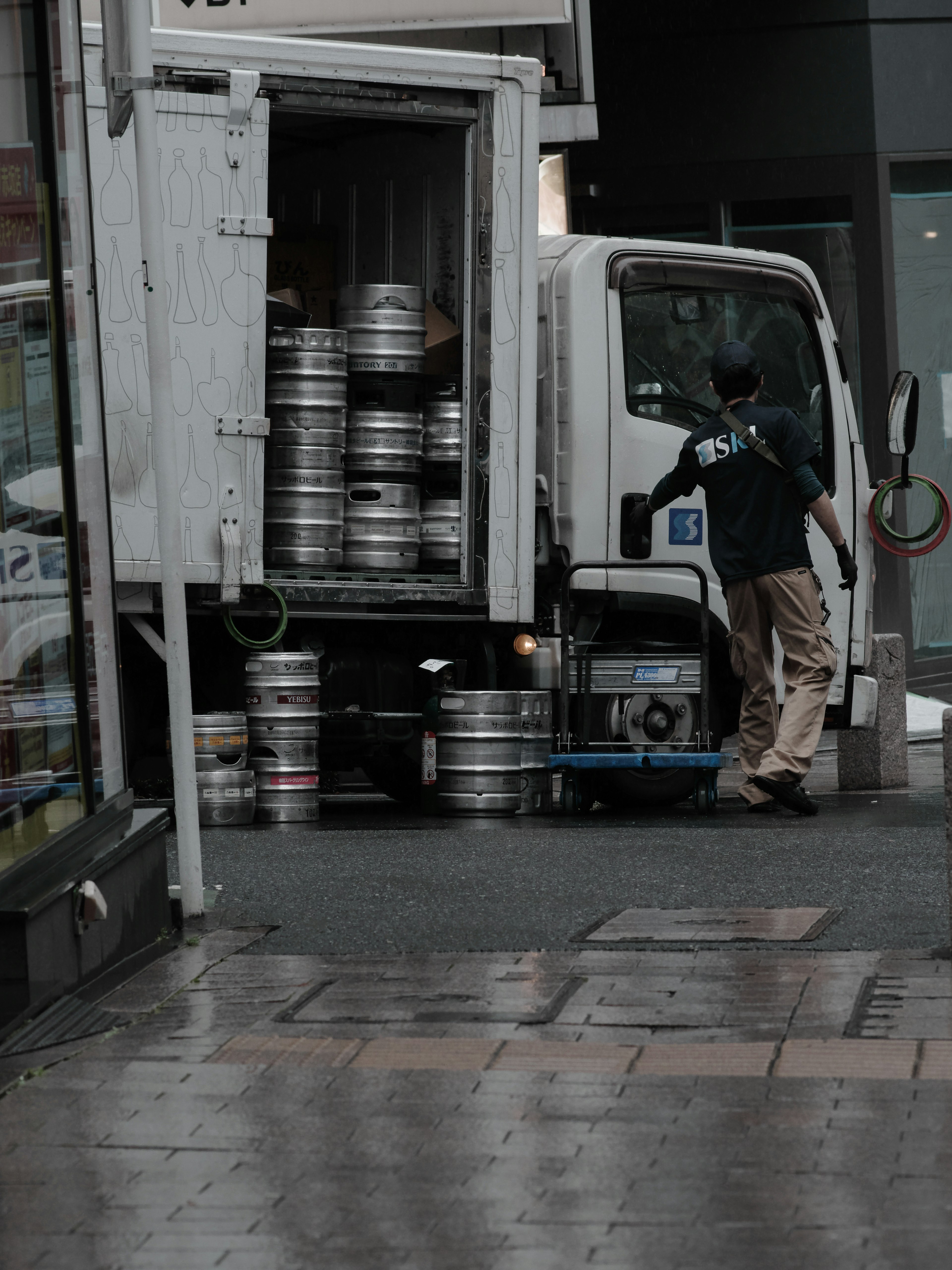 トラックにビール樽を積む作業員の風景