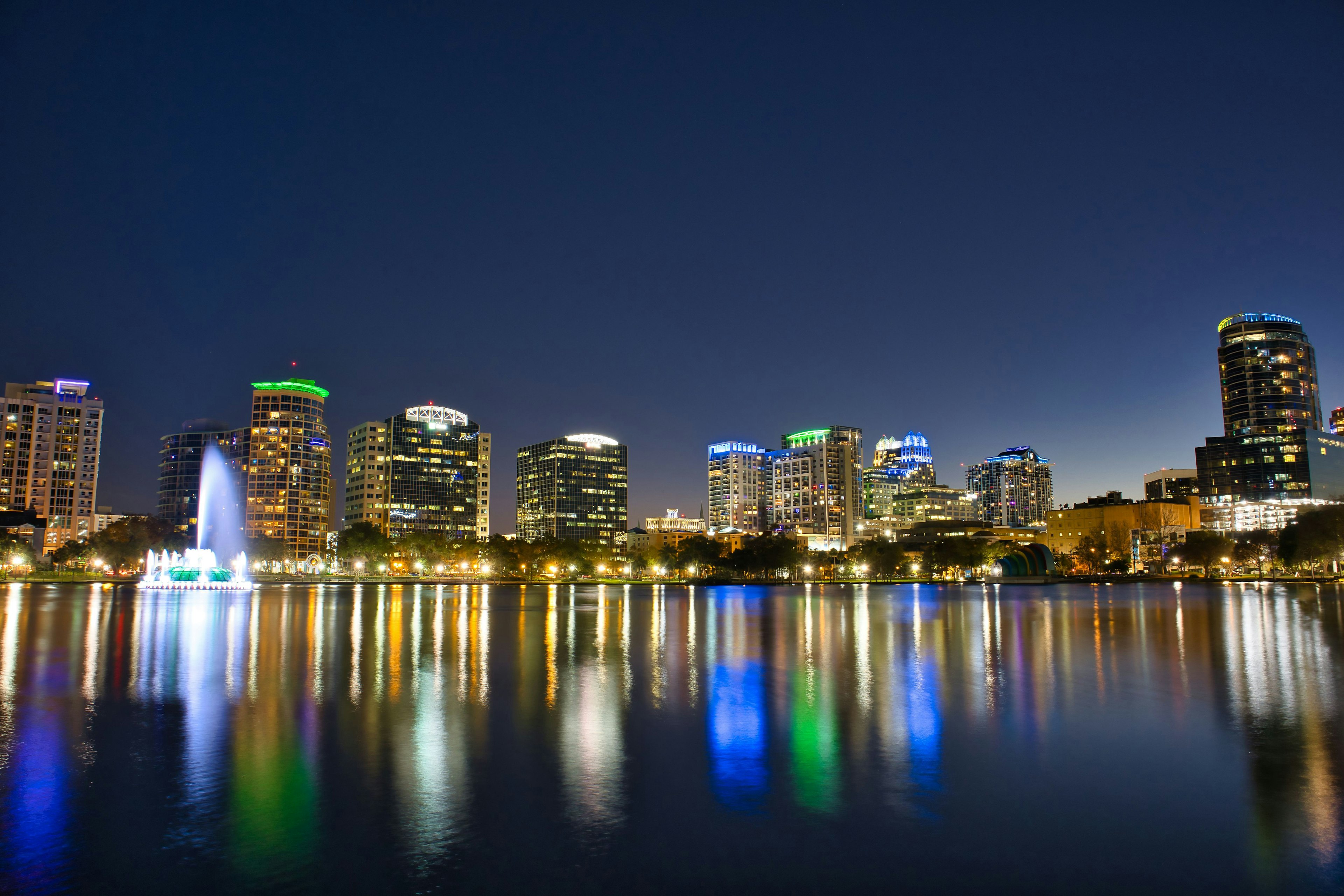 Vista notturna dello skyline di Orlando riflesso nel lago con luci colorate