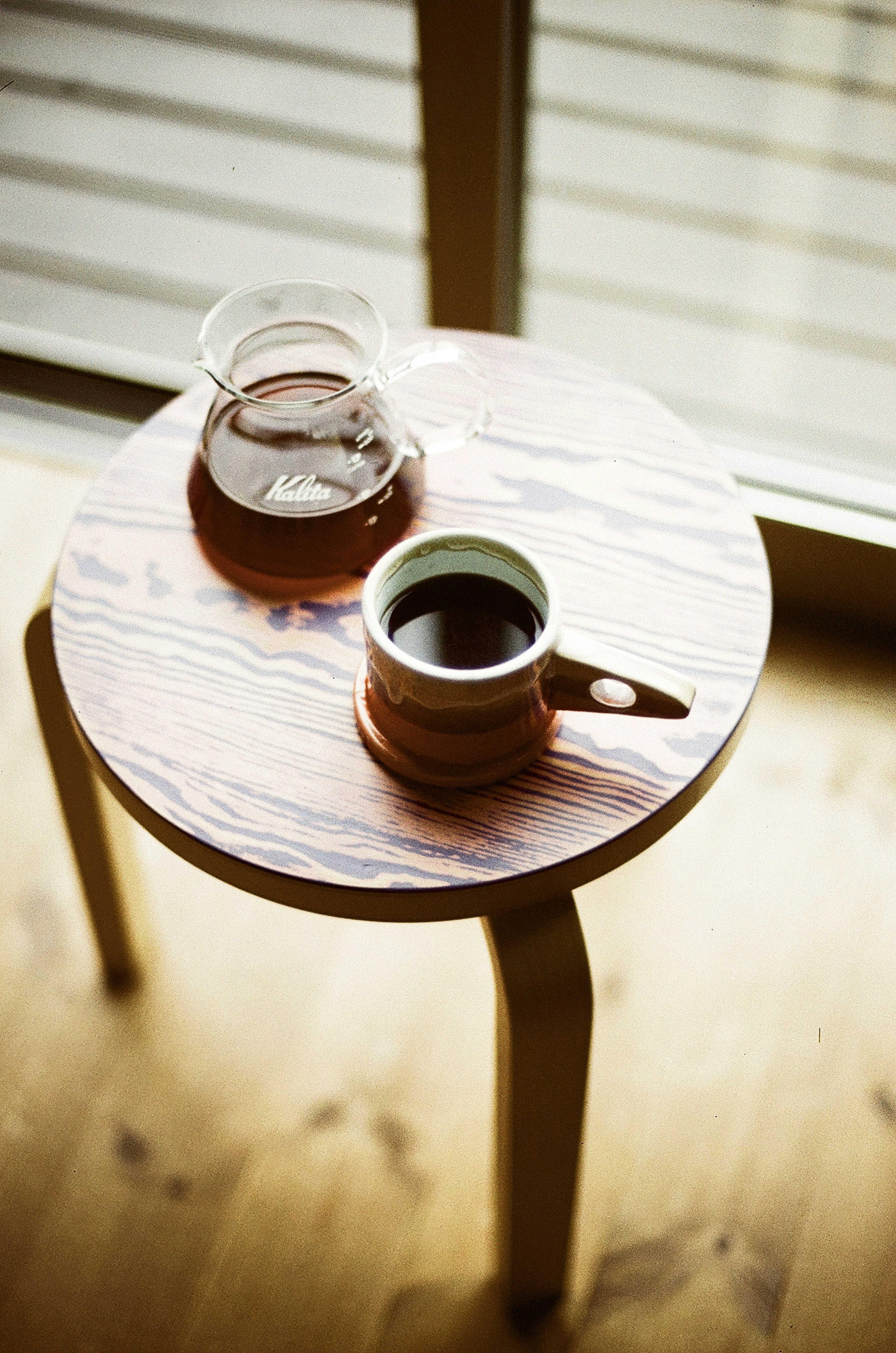 Cangkir kopi dan teko di atas meja kayu