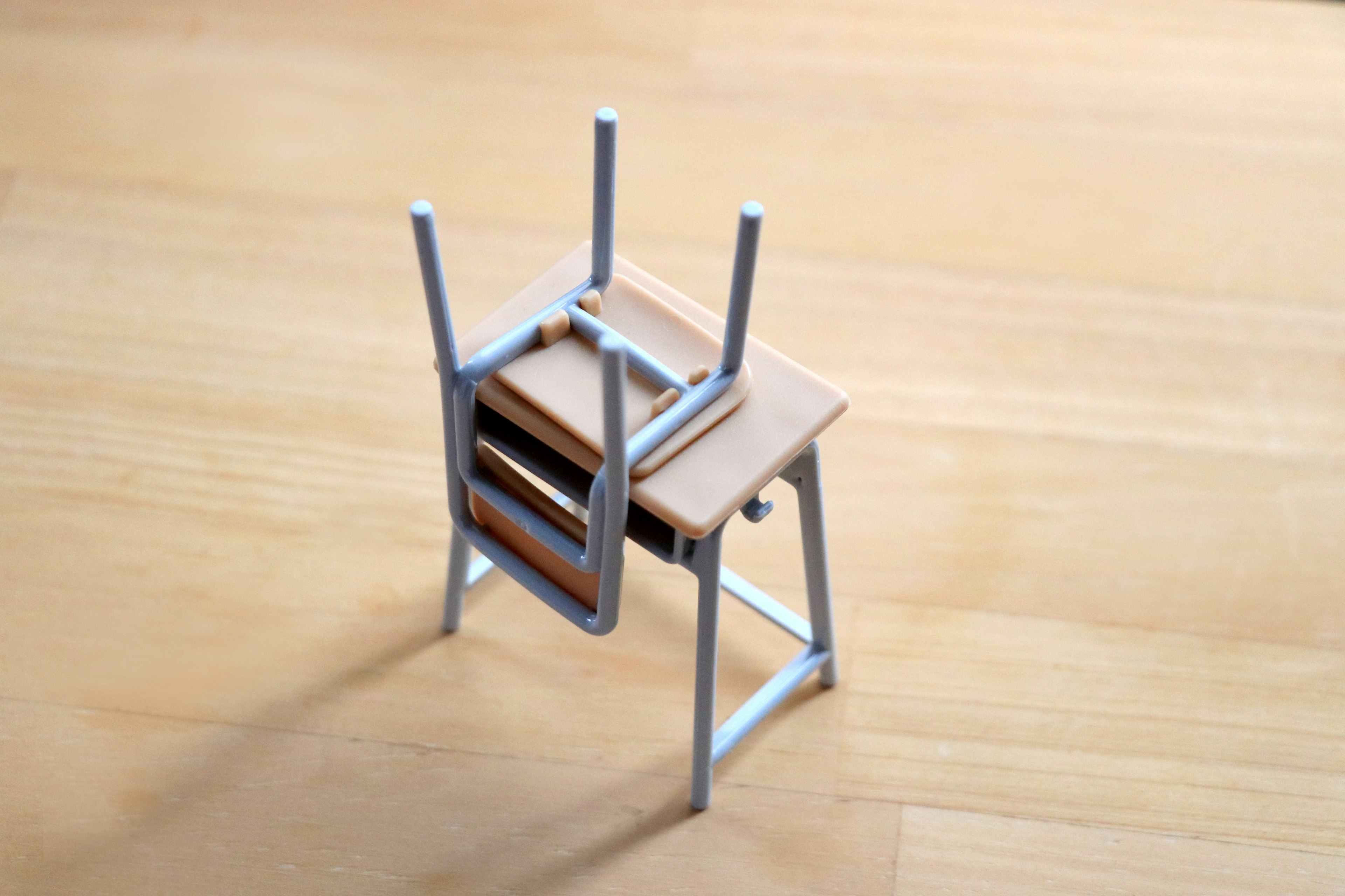 Miniature chair and desk placed on a wooden table