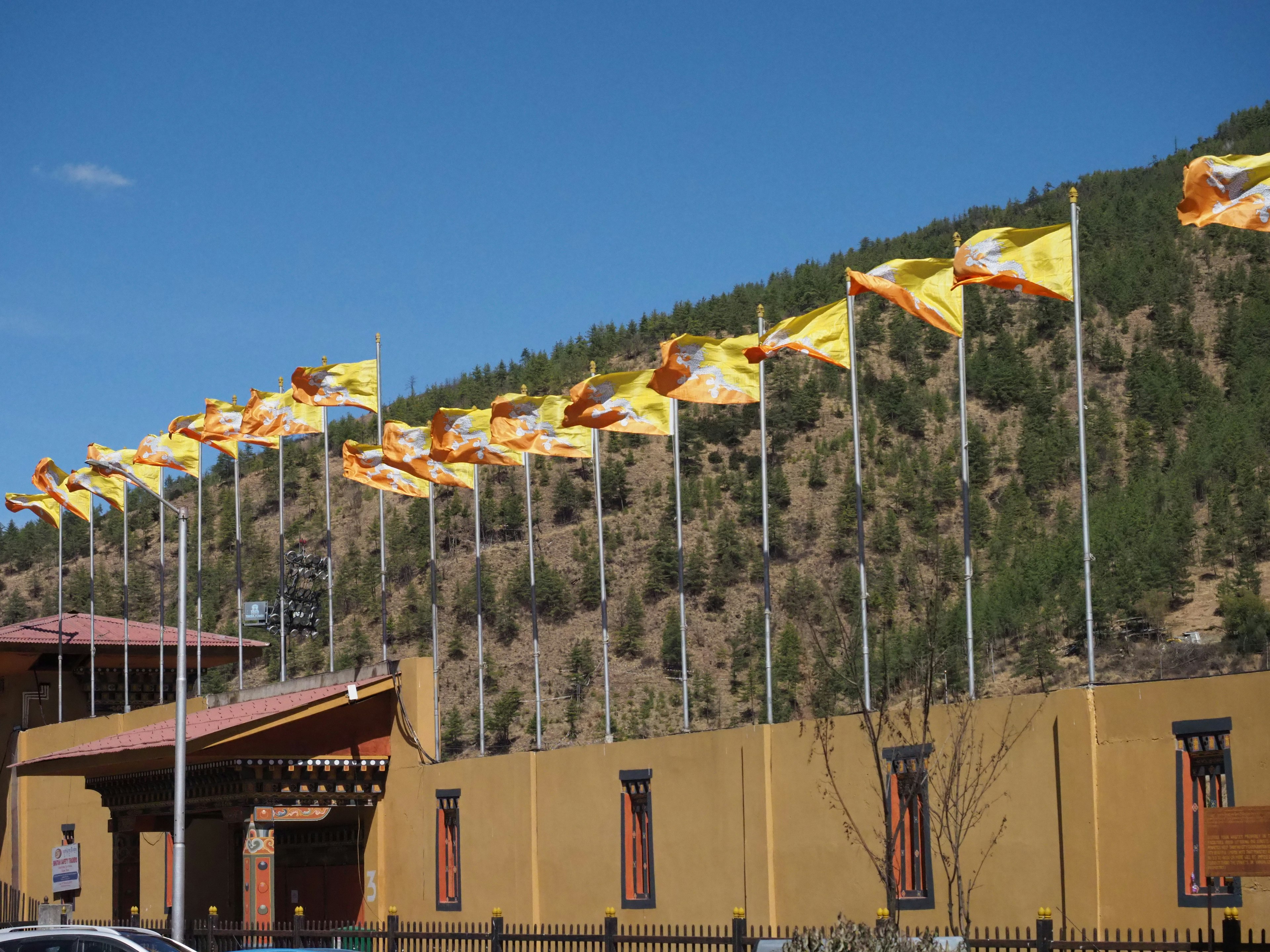 Bâtiment avec de nombreux drapeaux flottants sur une colline